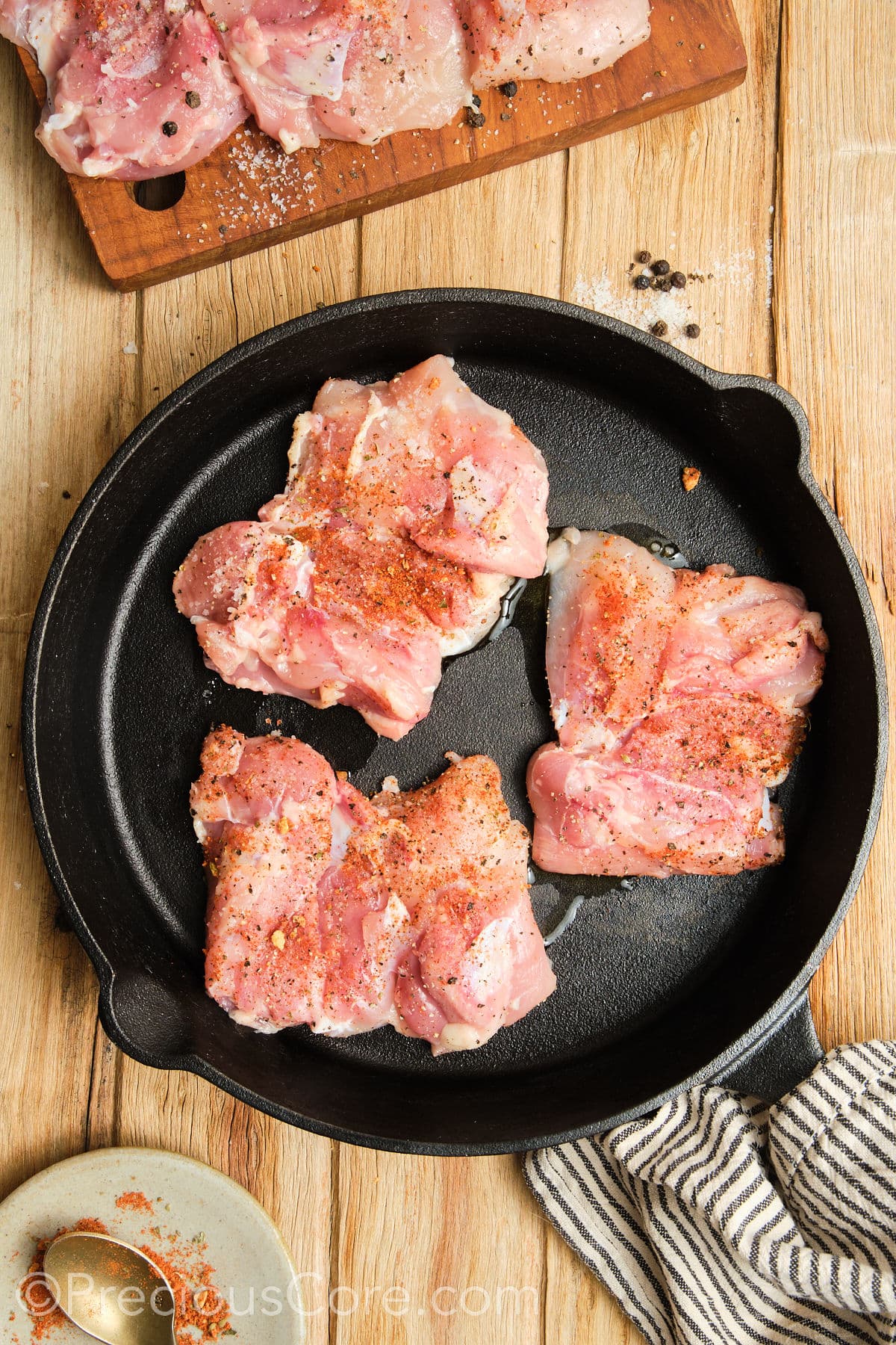 Cooking chicken thighs in a cast iron skillet.