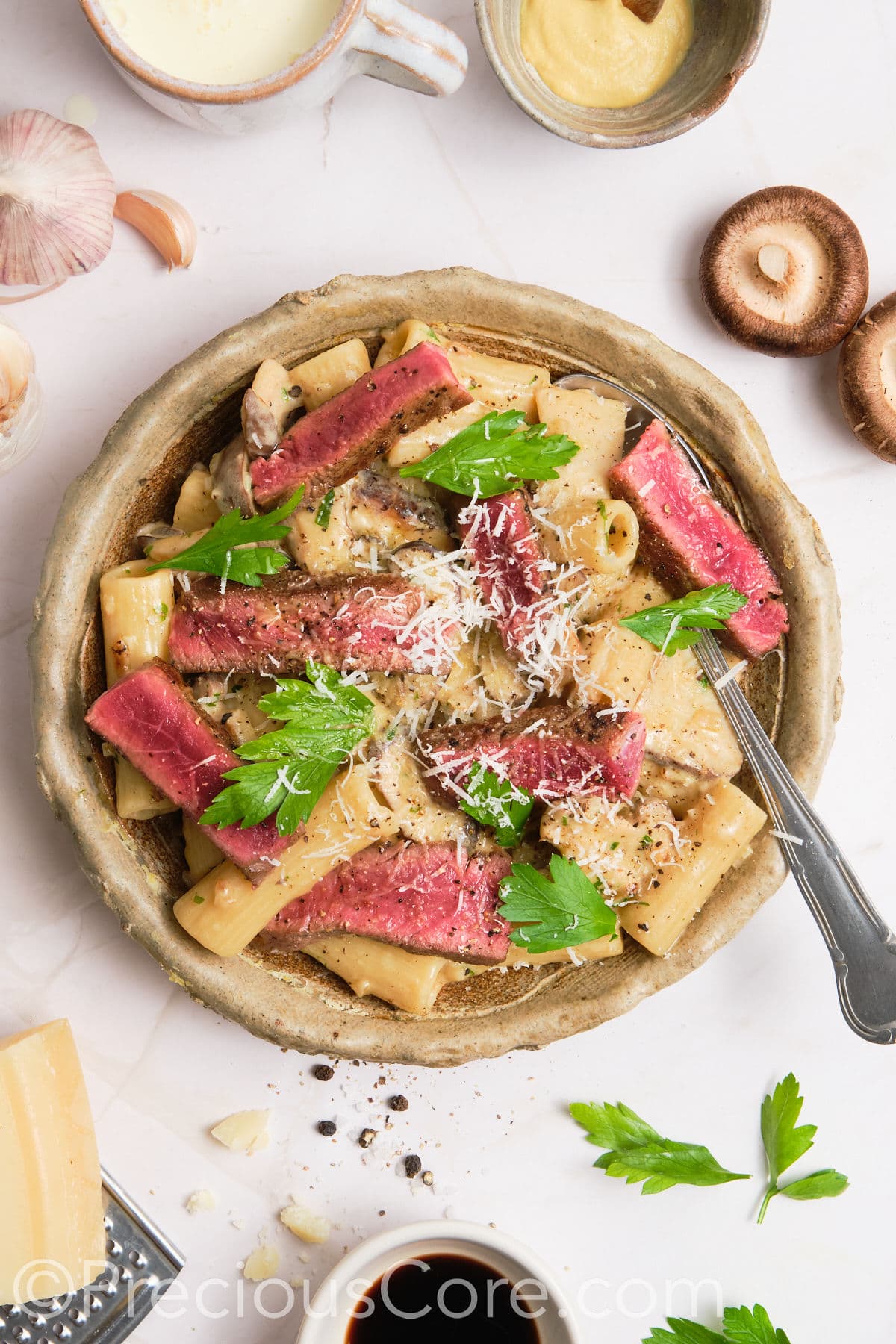 Pasta served topped with steak.