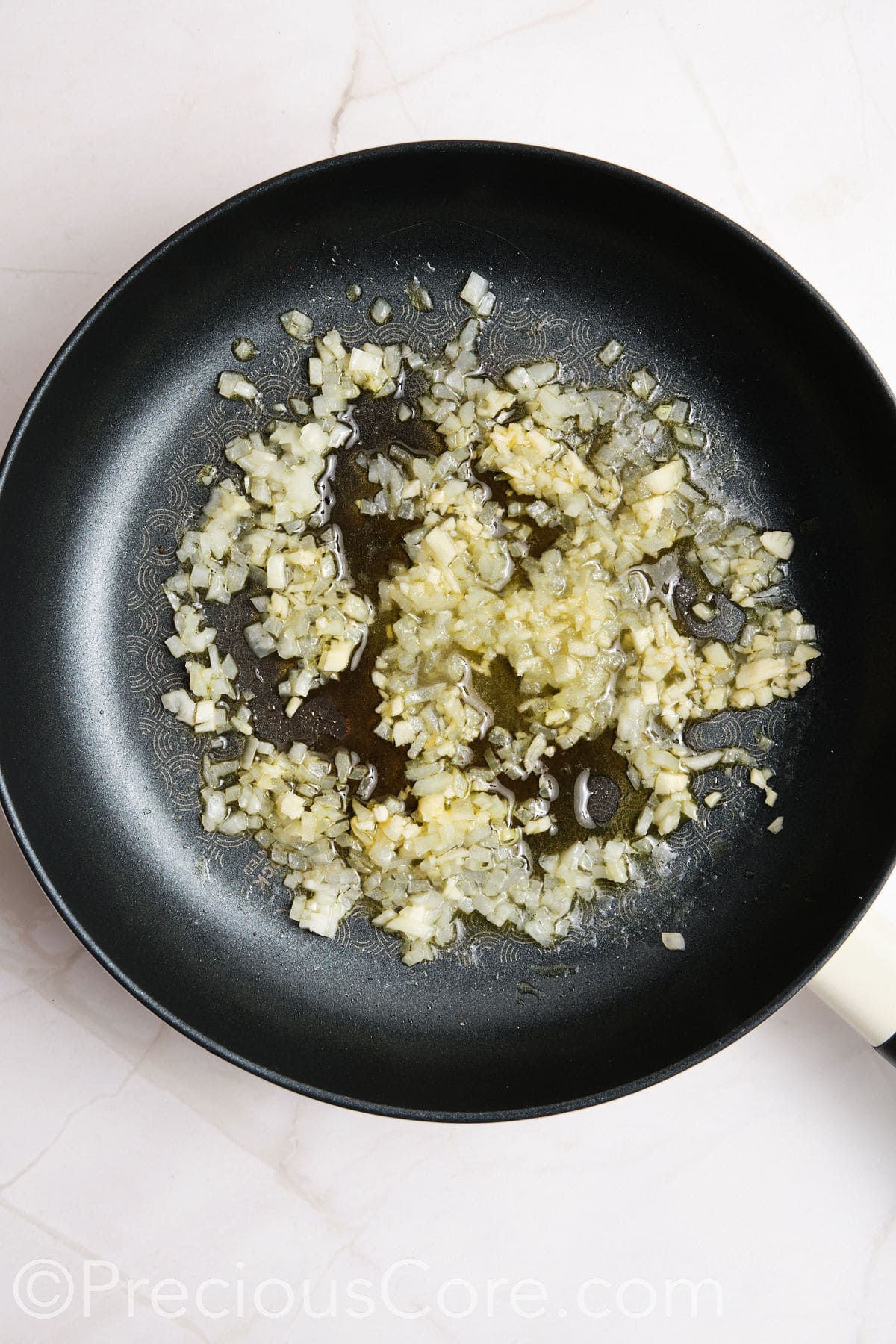 Onions and other ingredients cooking in a skillet.