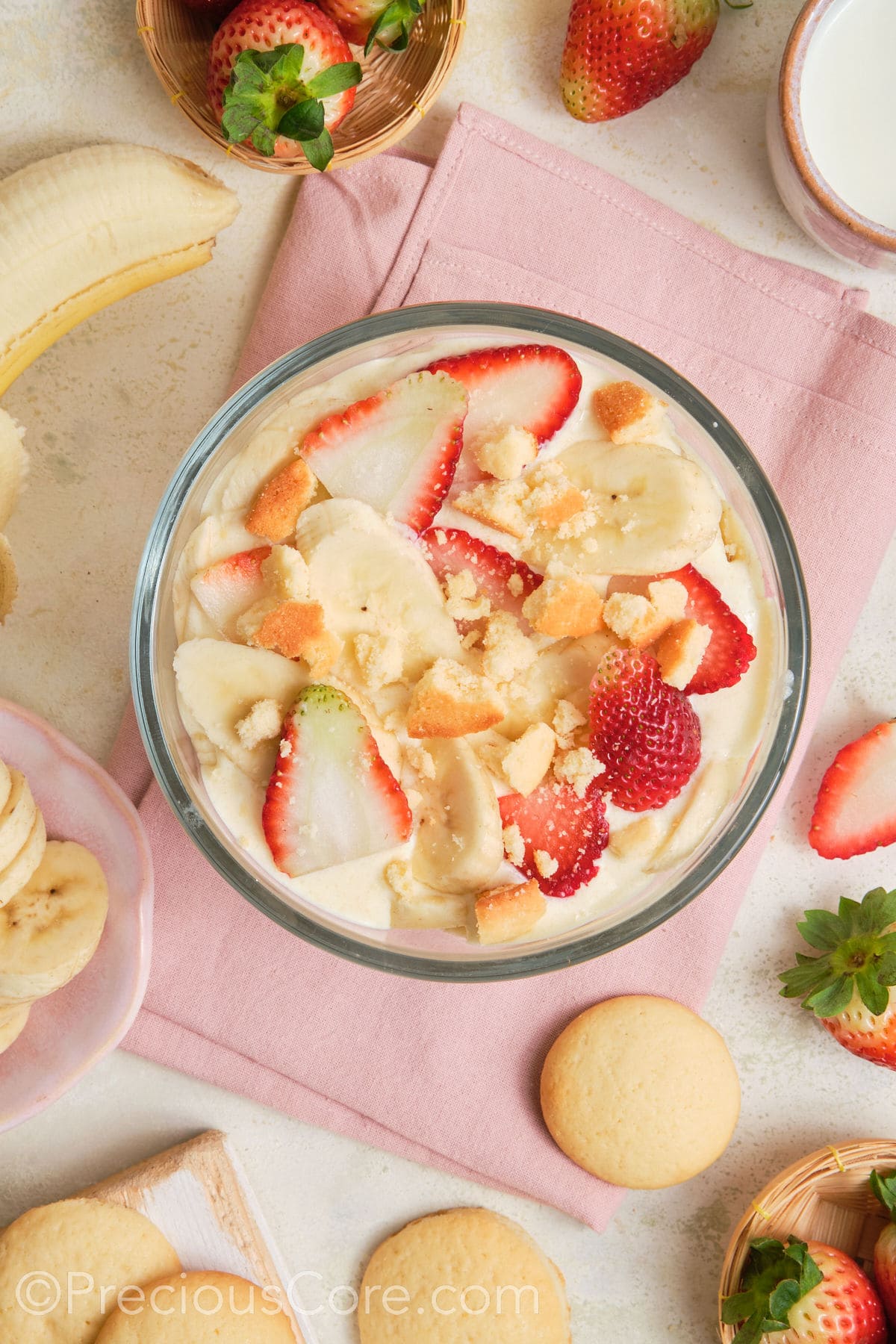 Banana pudding topped with strawberries and vanilla wafers.