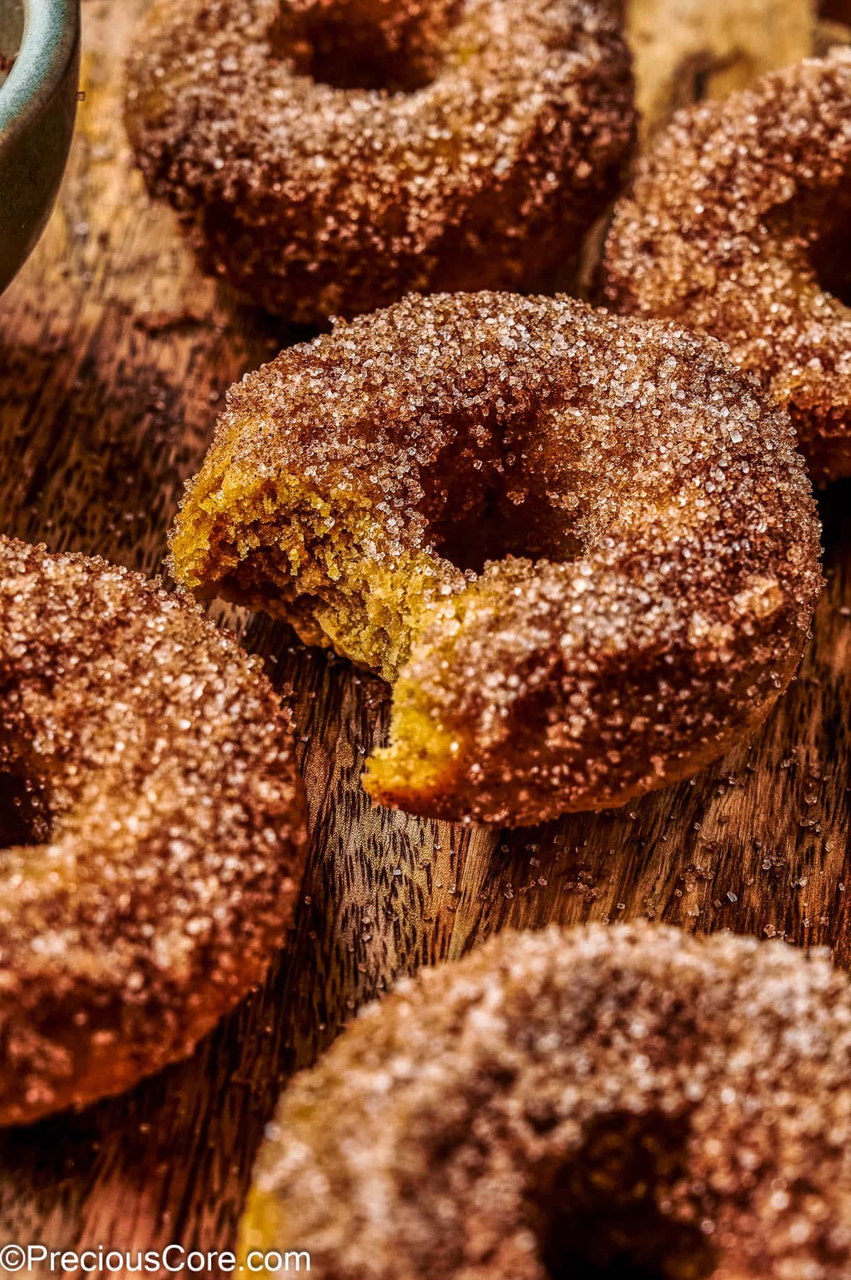 Baked pumpkin doughnuts on a wooden board.