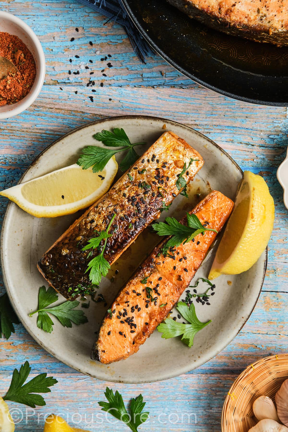 Cooked salmon on a plate garnished with fresh parsley.