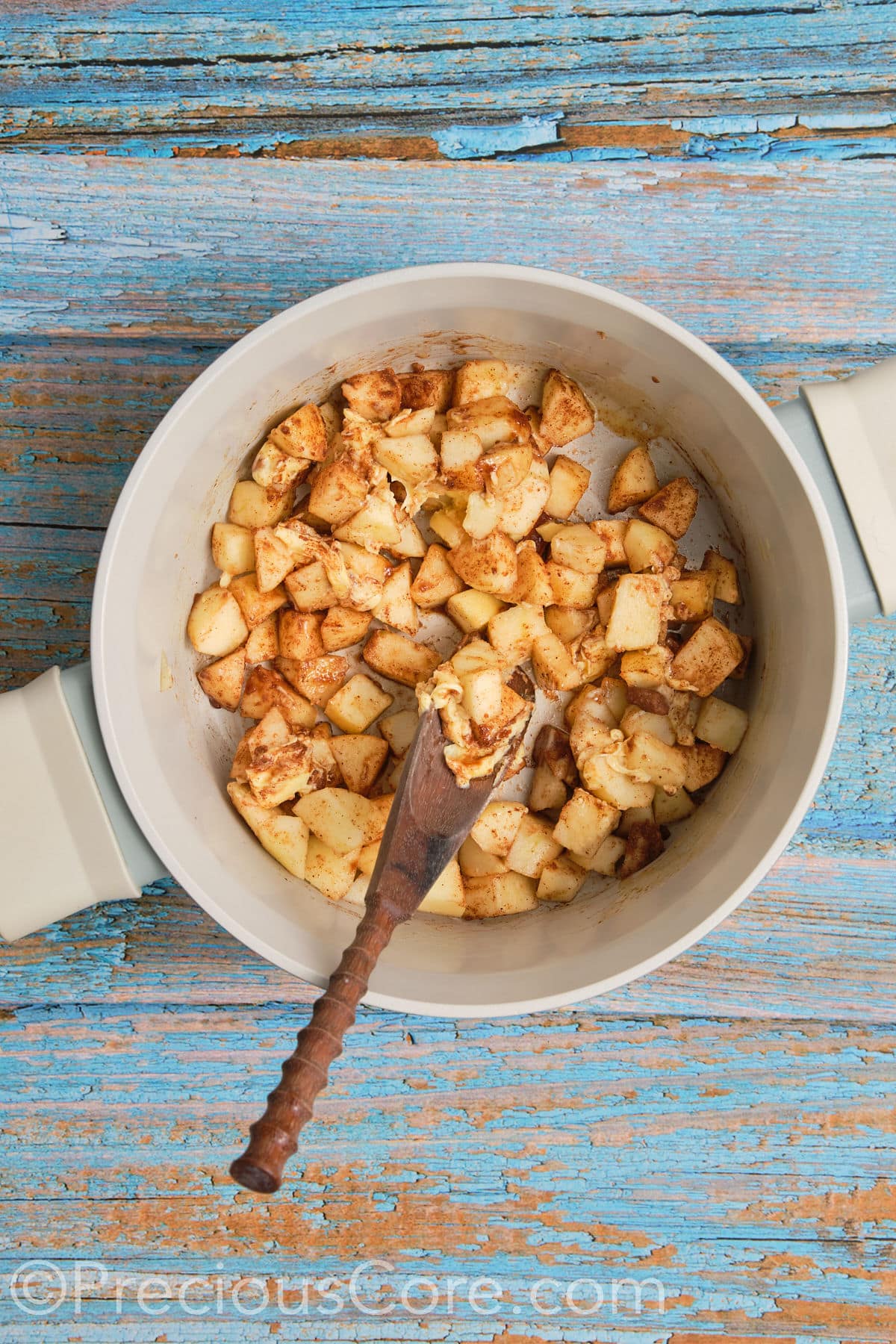 Apple pie filling for cinnamon rolls cooking in a pot.