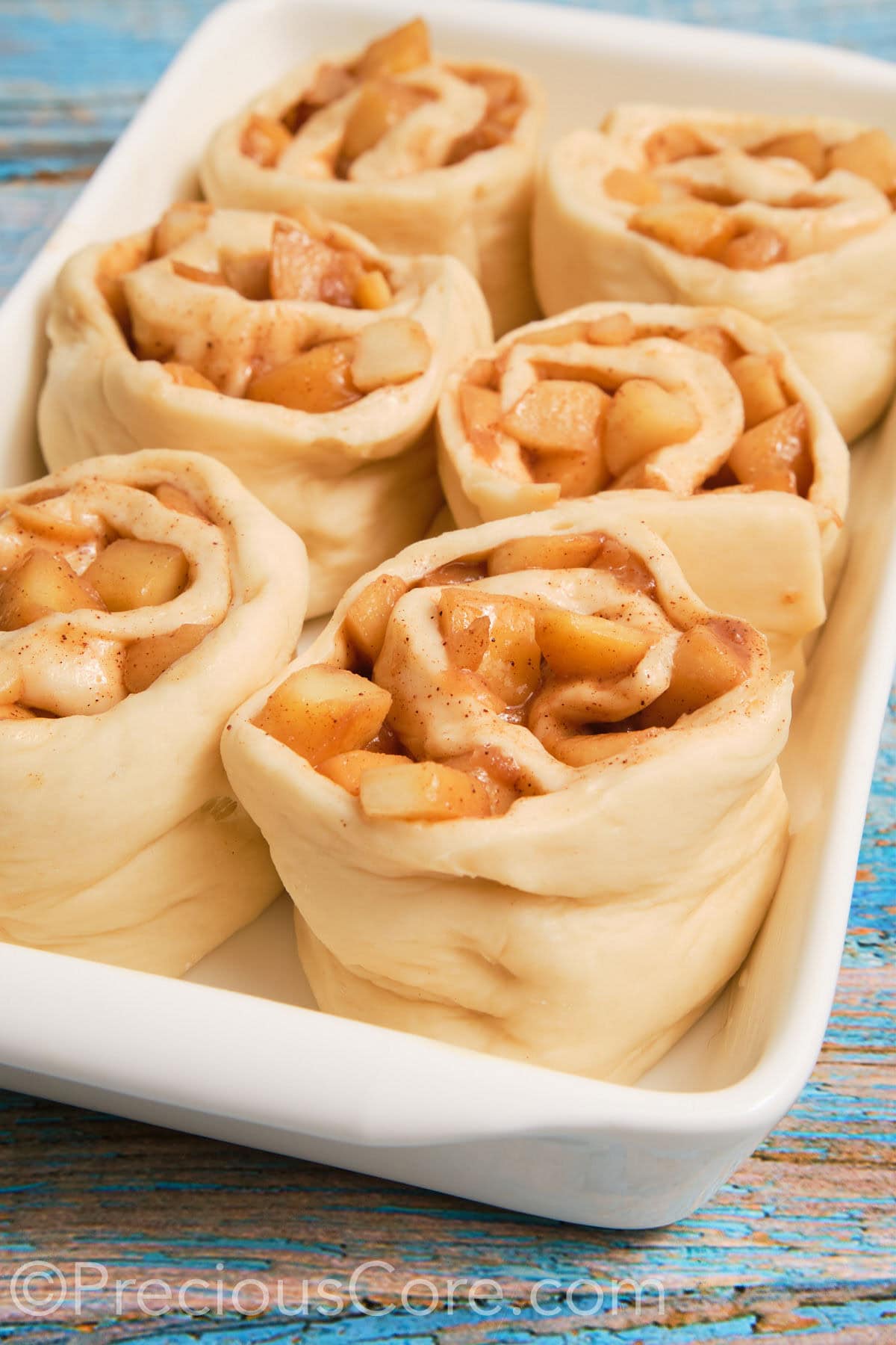 Close up of dough filled with apple pie filling.