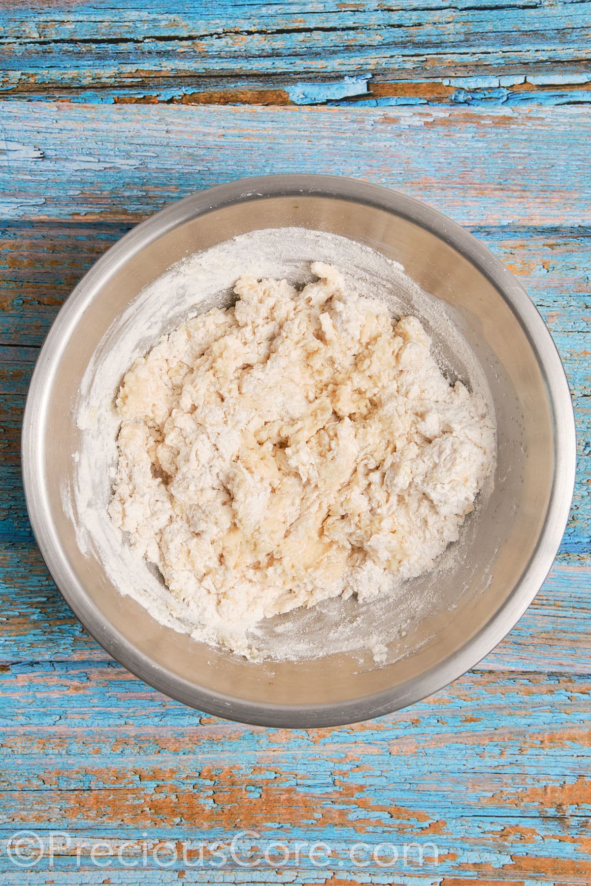 Mixing flour into wet ingredients for dough.