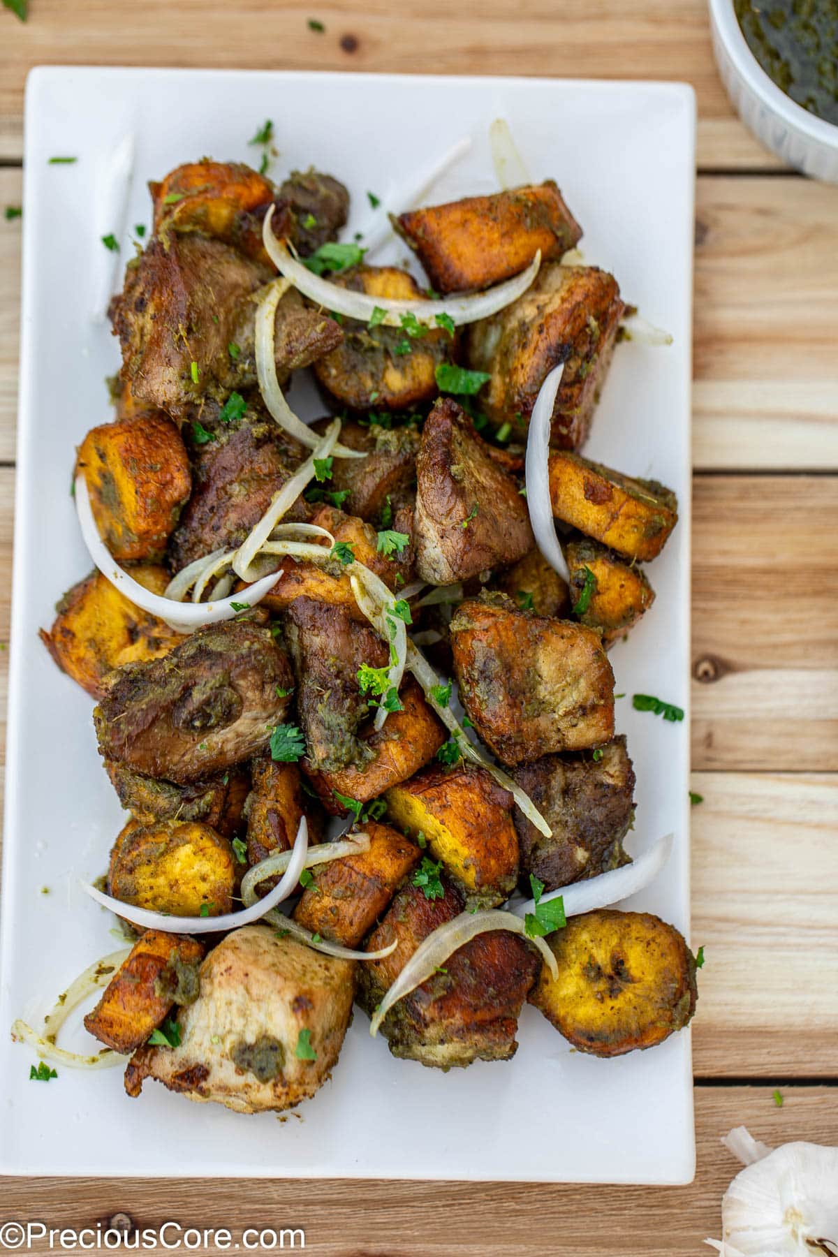 Fried pork an plantains topped with sliced onions.