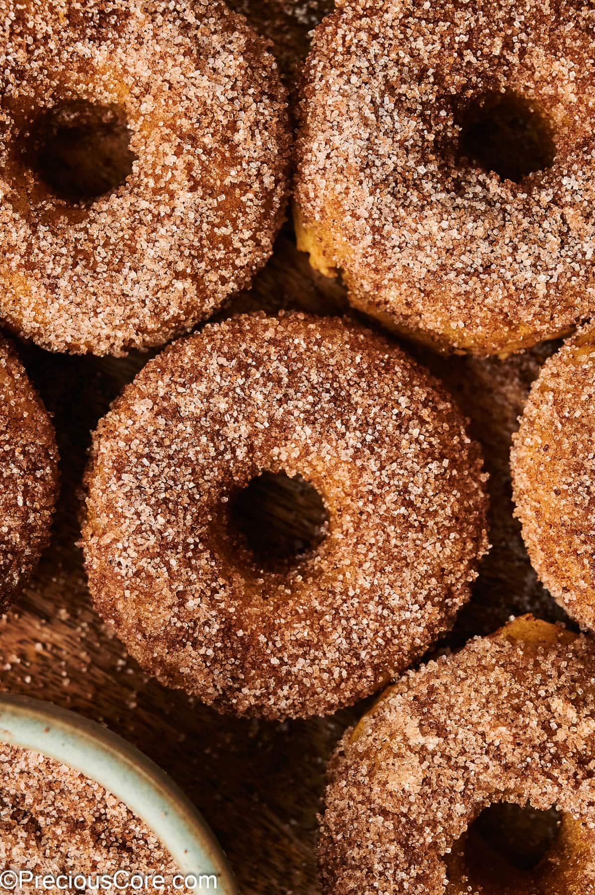 Pumpkin doughnuts coated in cinnamon sugar.