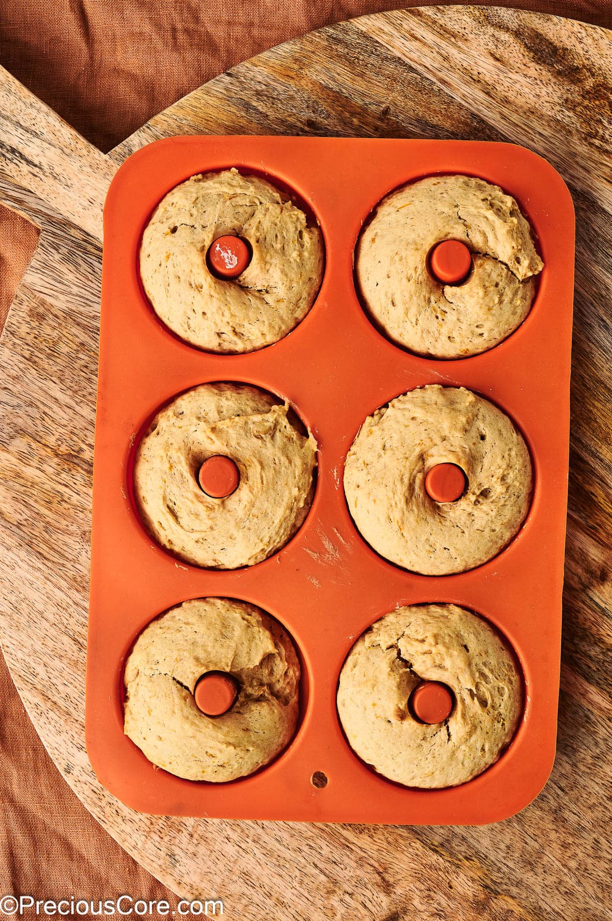 Baked pumpkin spice doughnuts in doughnut pan.