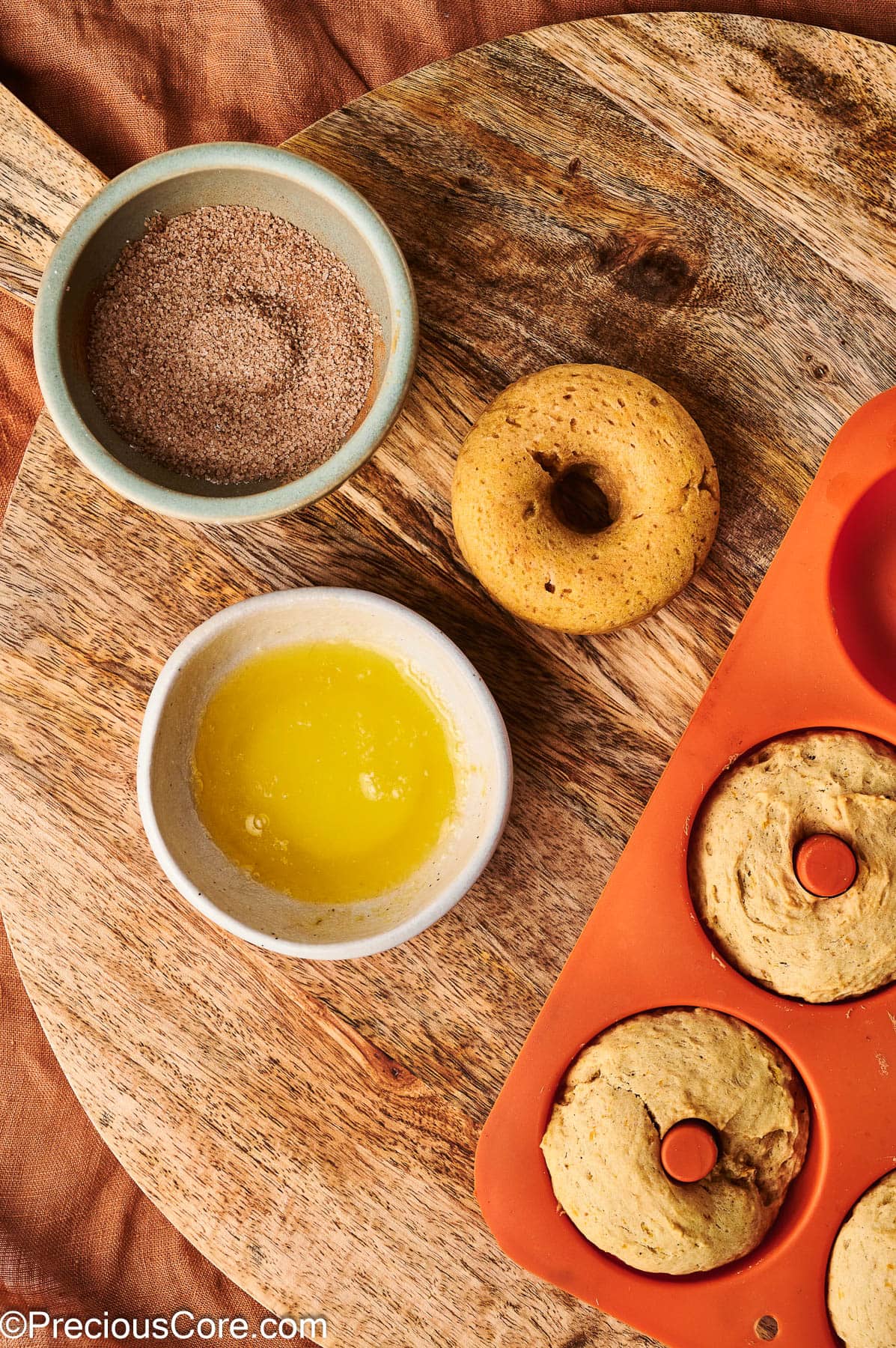 Preparing to coat doughnuts with cinnamon sugar.