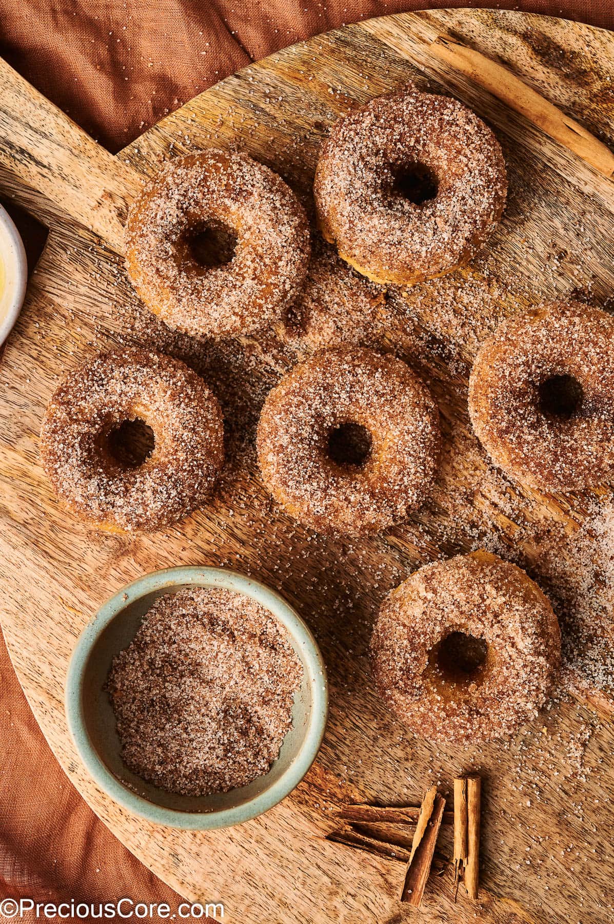 All six baked doughnuts coated in cinnamon sugar.