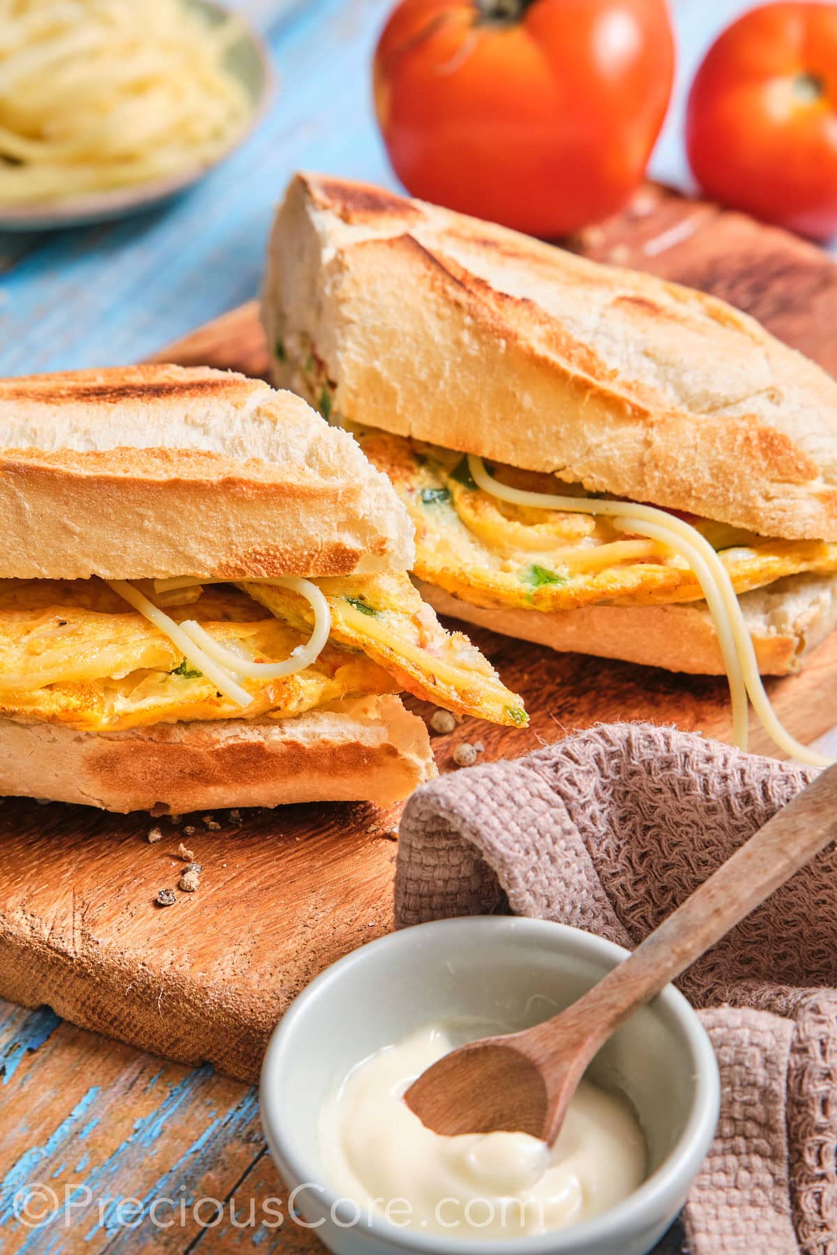 French baguette stuffed with spaghetti omelette and cut in half.