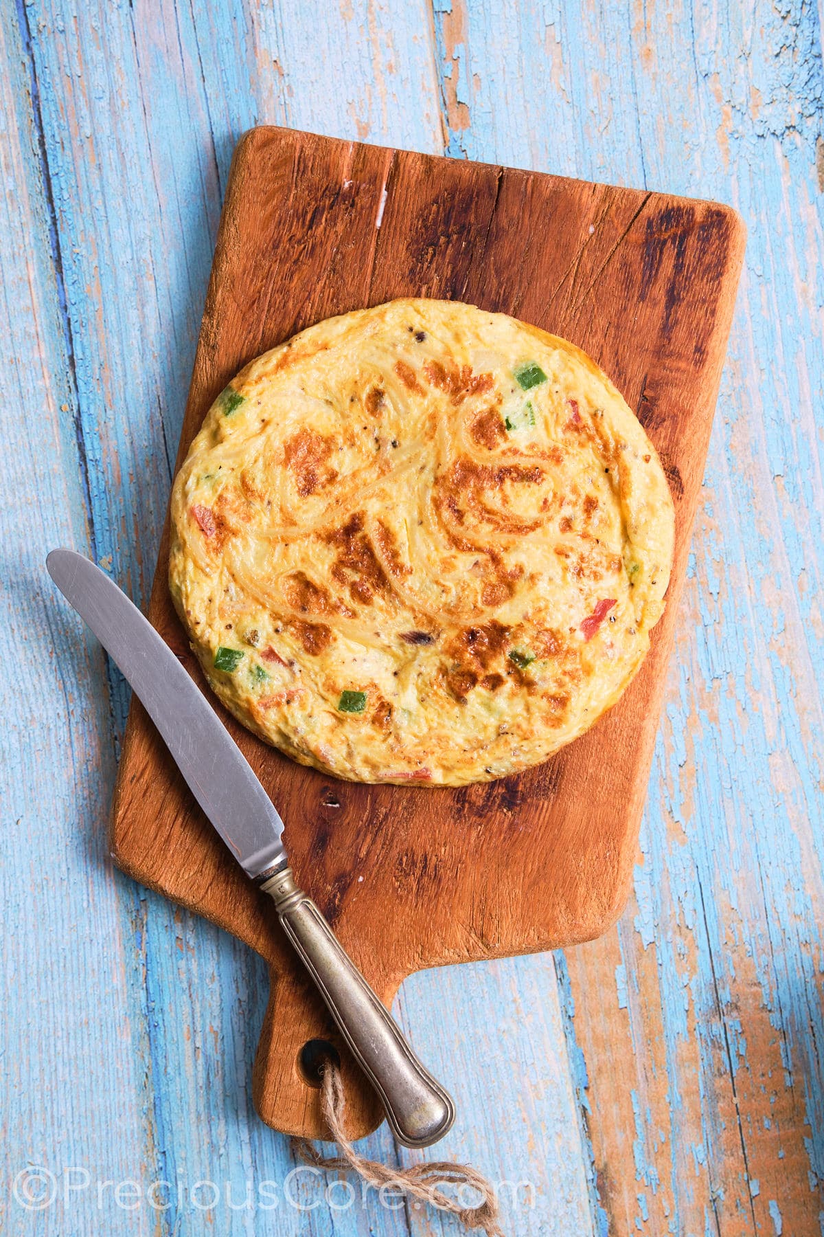 Spaghetti omelette placed on a cutting board.