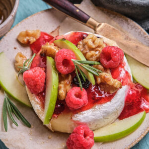 Served round of baked brie and preserves with melty cheese.