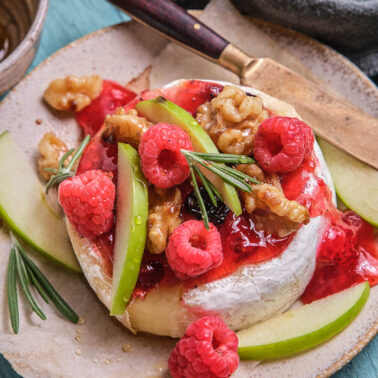 Square image of baked brie and preserves.