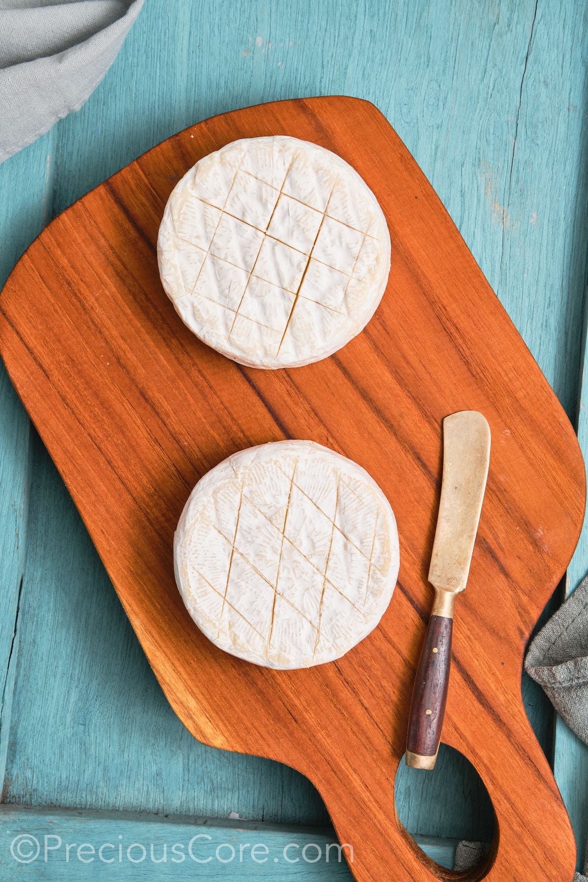 Two rounds of brie scored in a criss cross pattern.