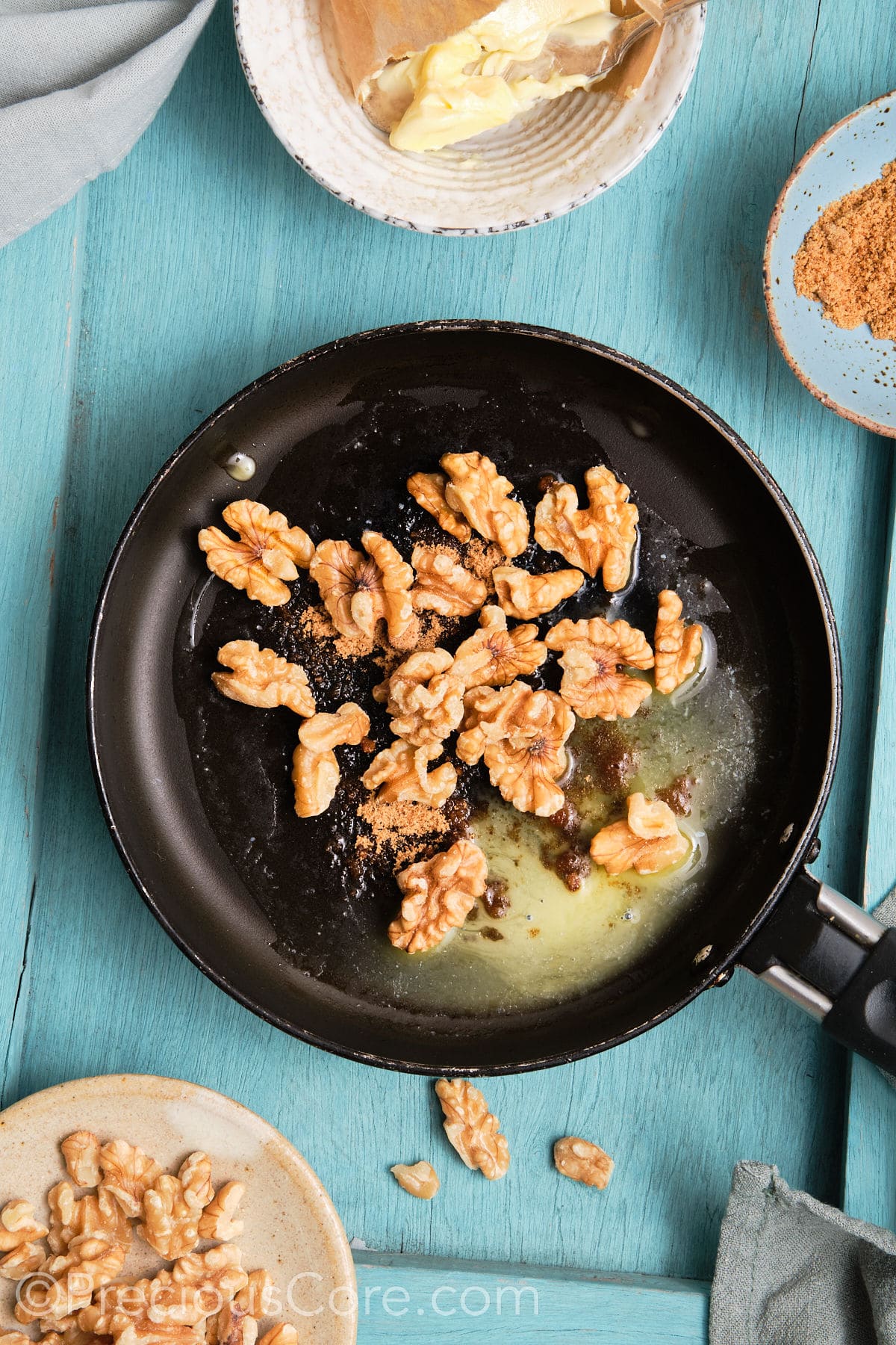 Walnuts in a skillet with brown sugar and butter.