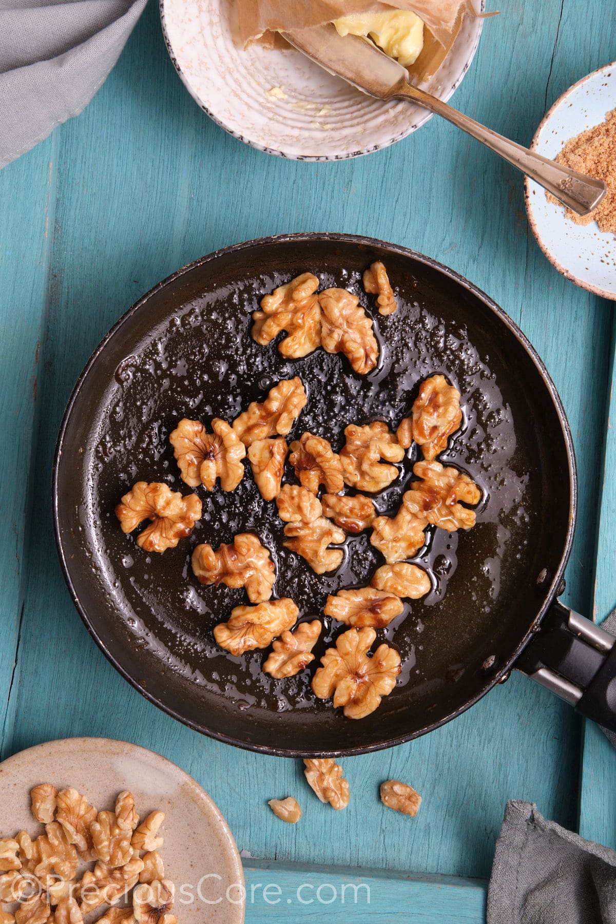 Caramelized walnuts in a small skillet.