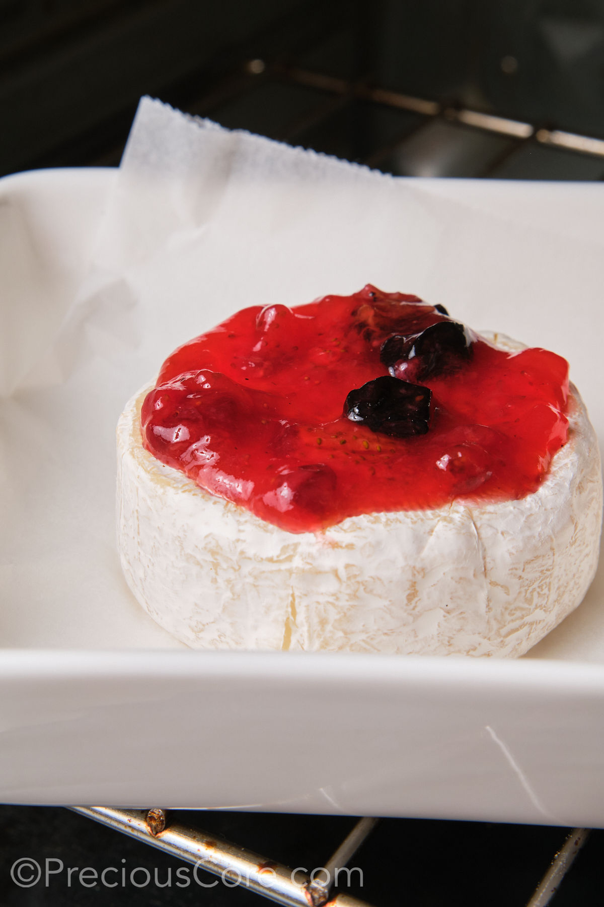 Baked Brie and fig preserves in the oven.