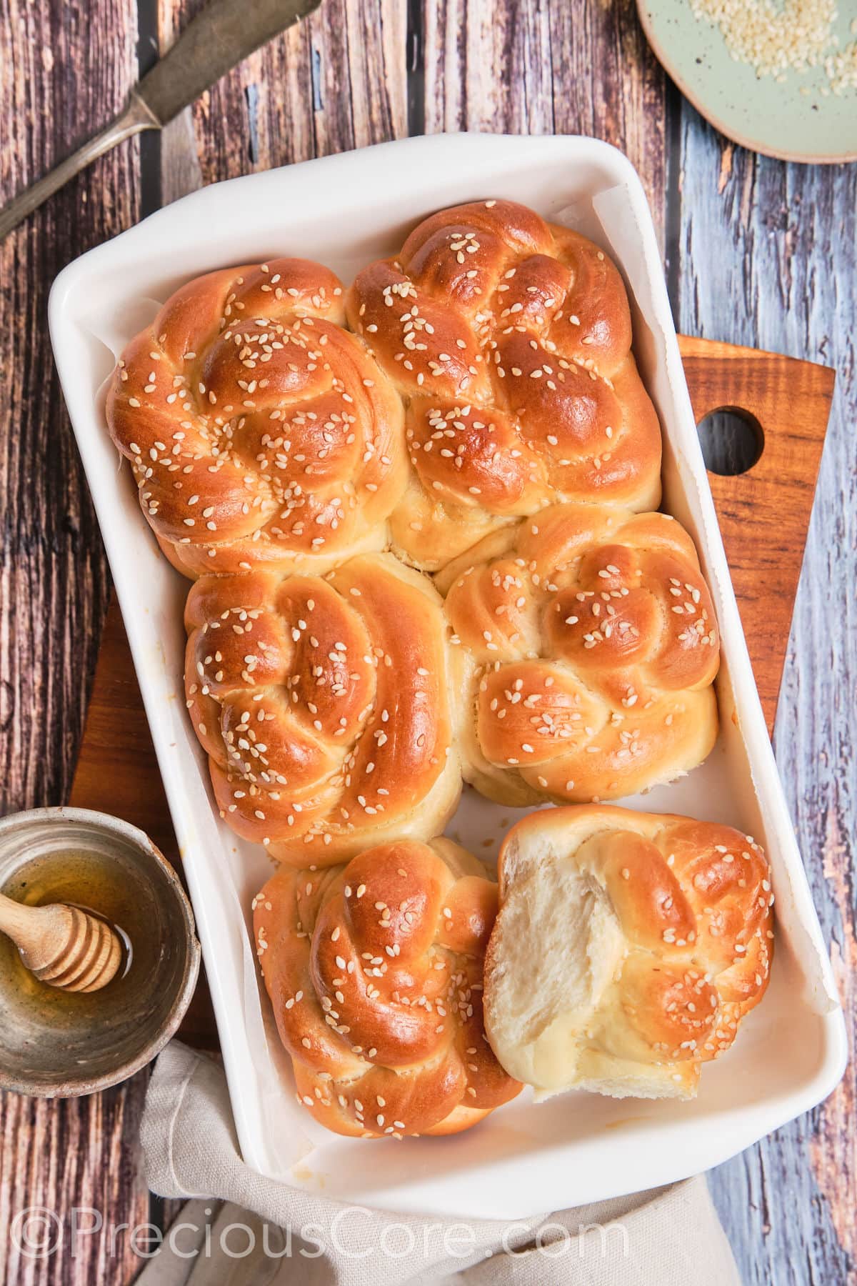 One challah roll pulled away to show texture.