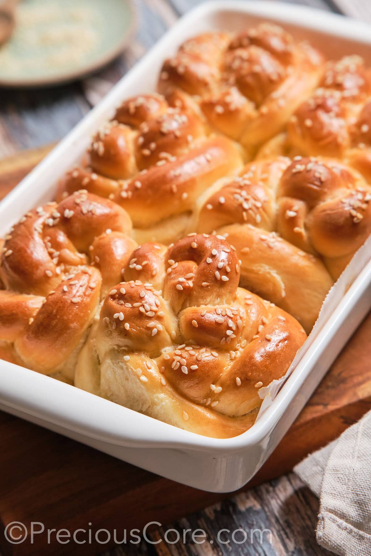 A baking dish with baked homemade challah rolls.