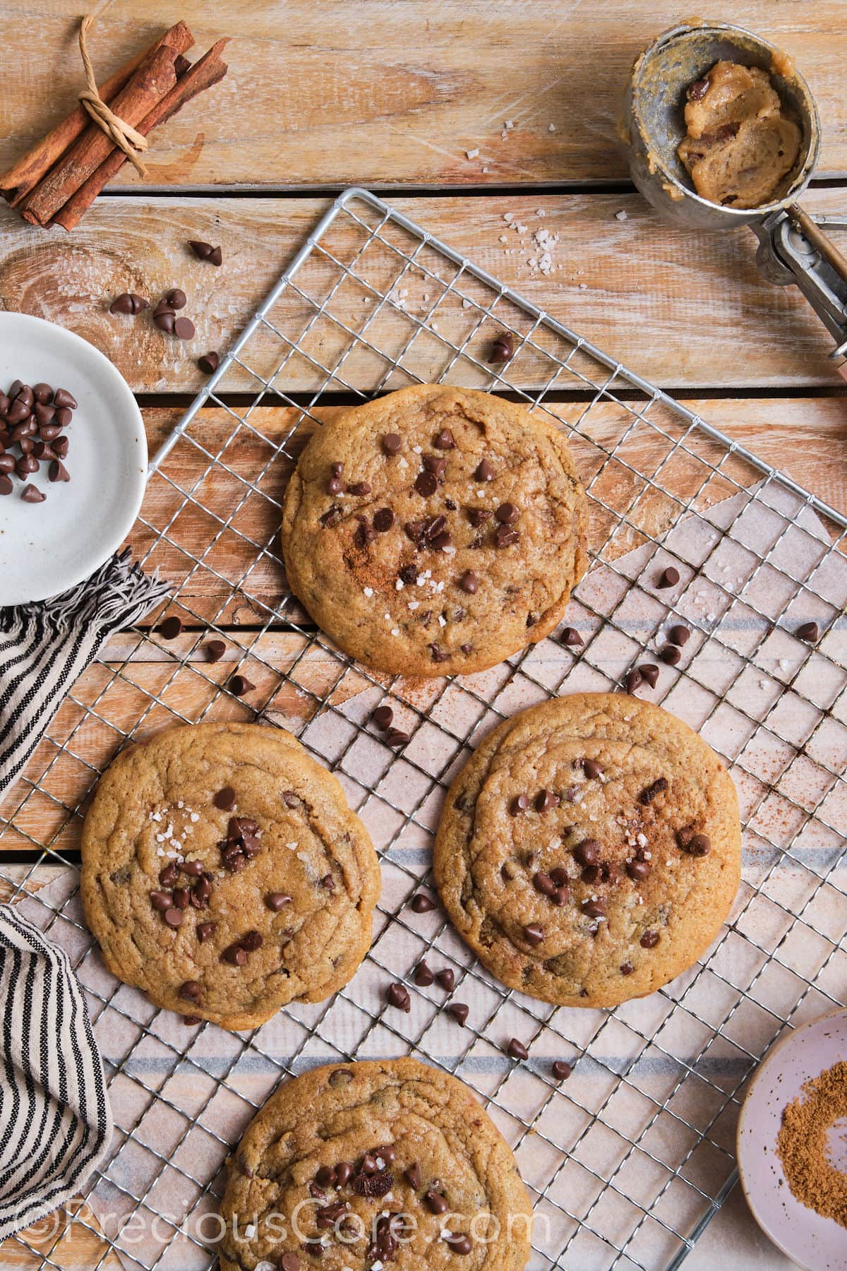 wire rack with cinnamon and chocolate chip cookies topped with flaky sea salt. 