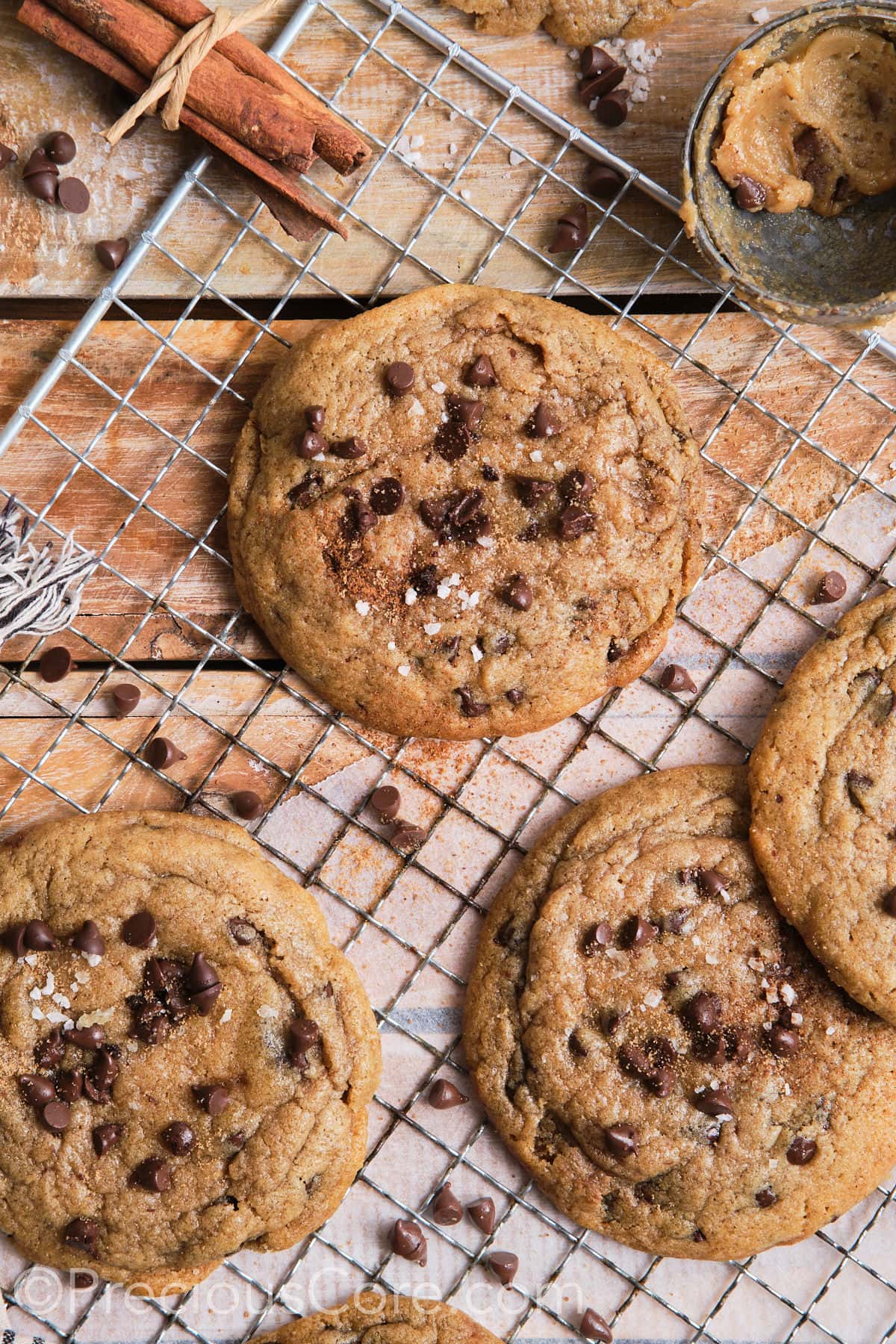 Cinnamon chocolate chip cookies on a wire rack, sprinkled with sea salt