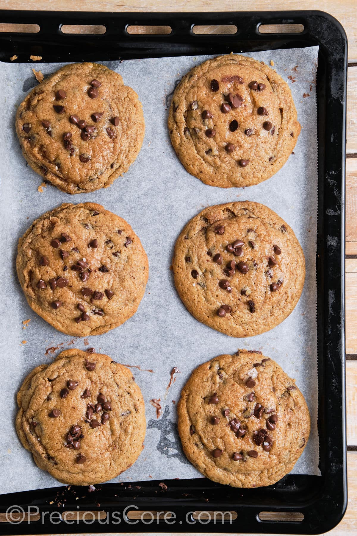 6 cinnamon chocolate chip cookies on a baking sheet.