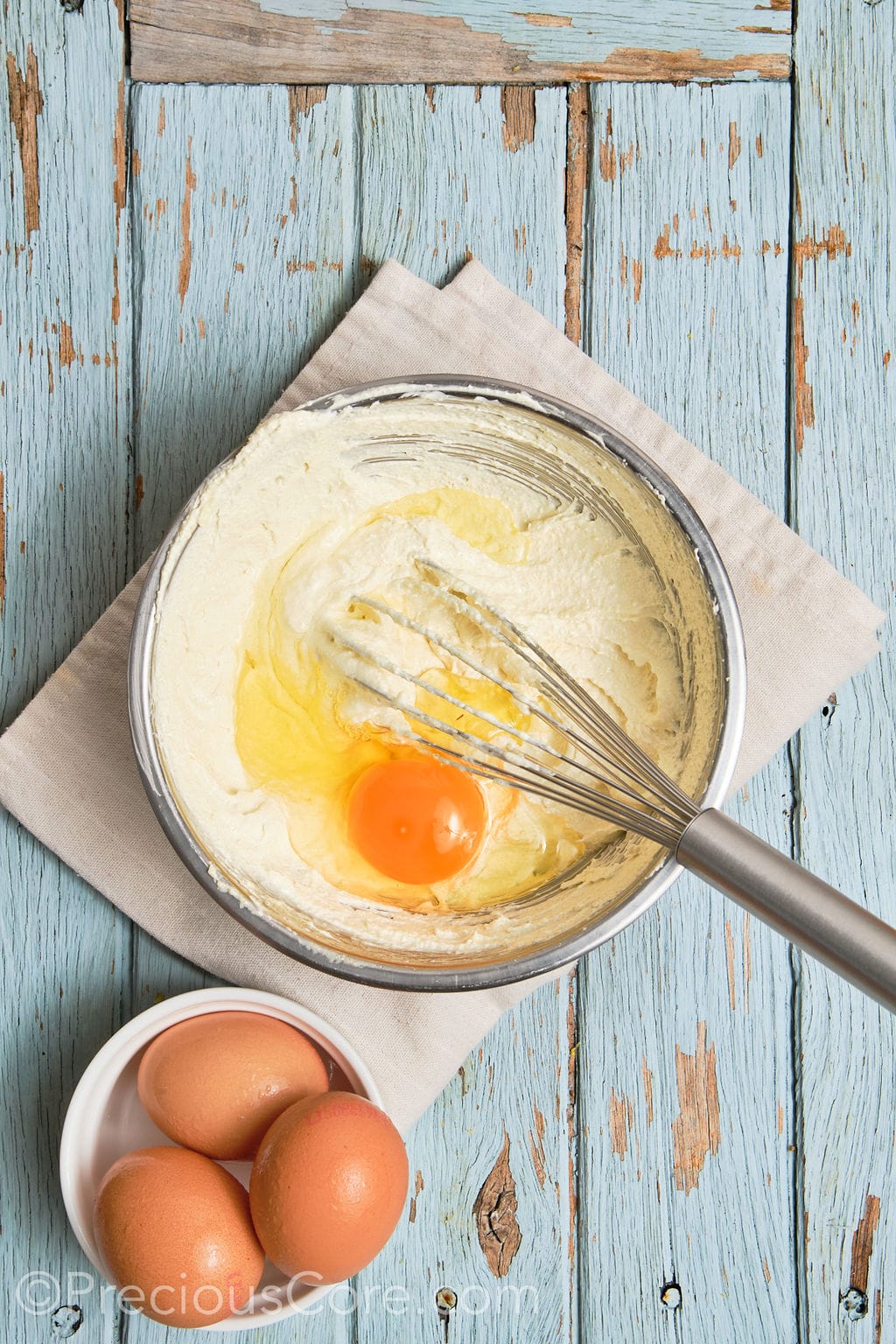 eggs whisked into a creamed butter mixture in a bowl. 