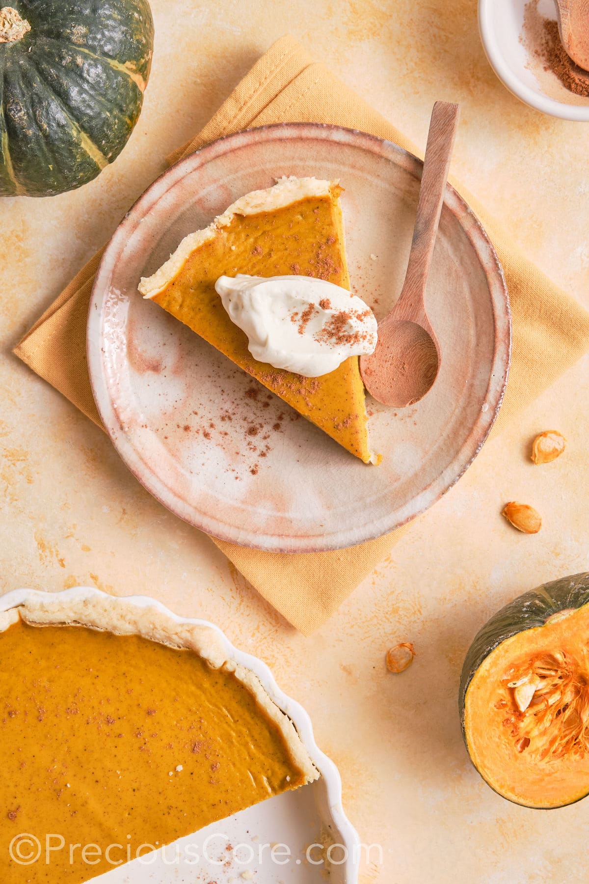 Slice of homemade pumpkin pie served with cream.