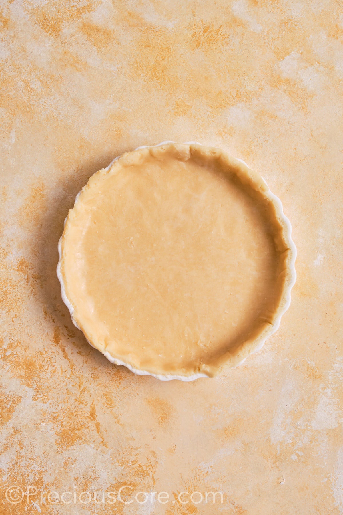 Pumpkin pie dough fitted into pie dish.