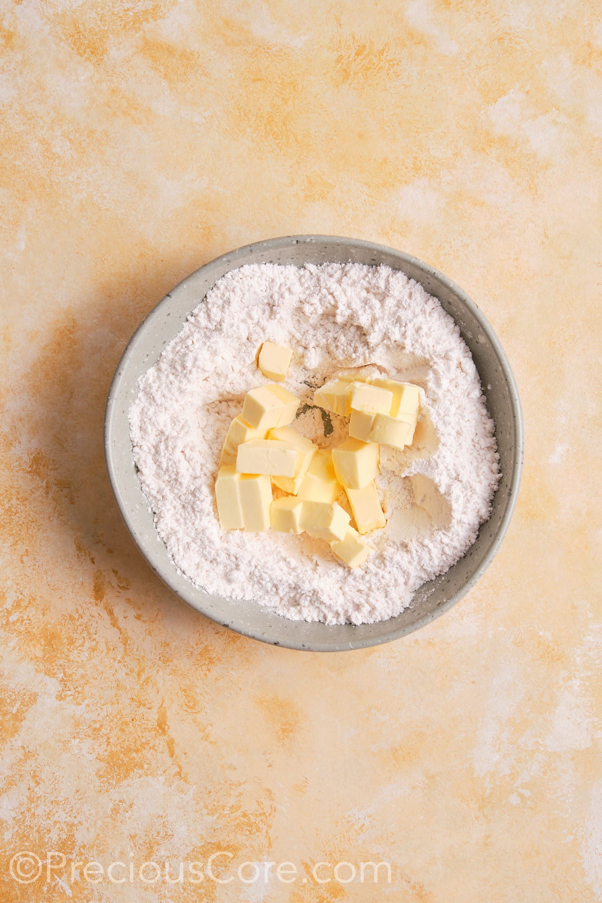 Dry ingredients and butter  for pie crust in a bowl.