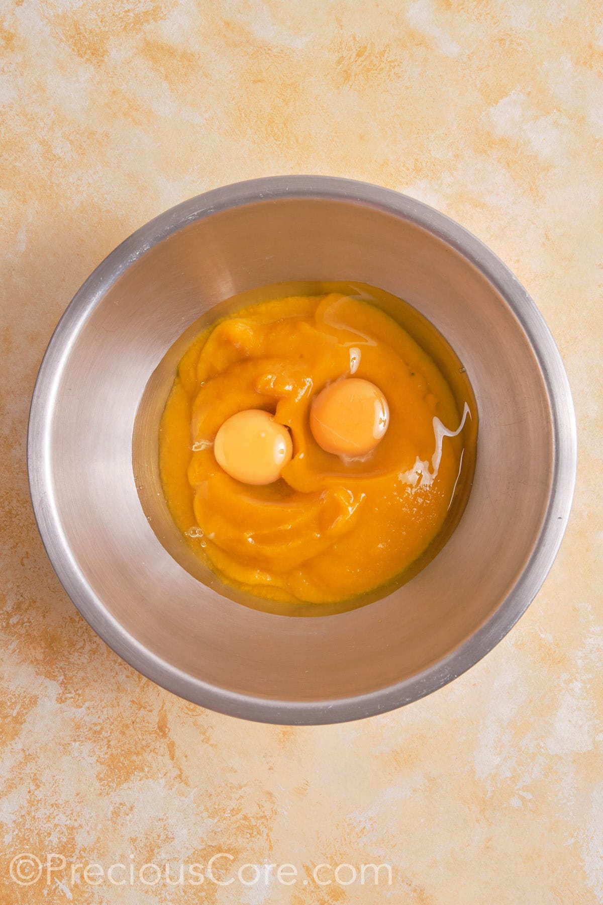 Eggs and pumpkin puree in a bowl.