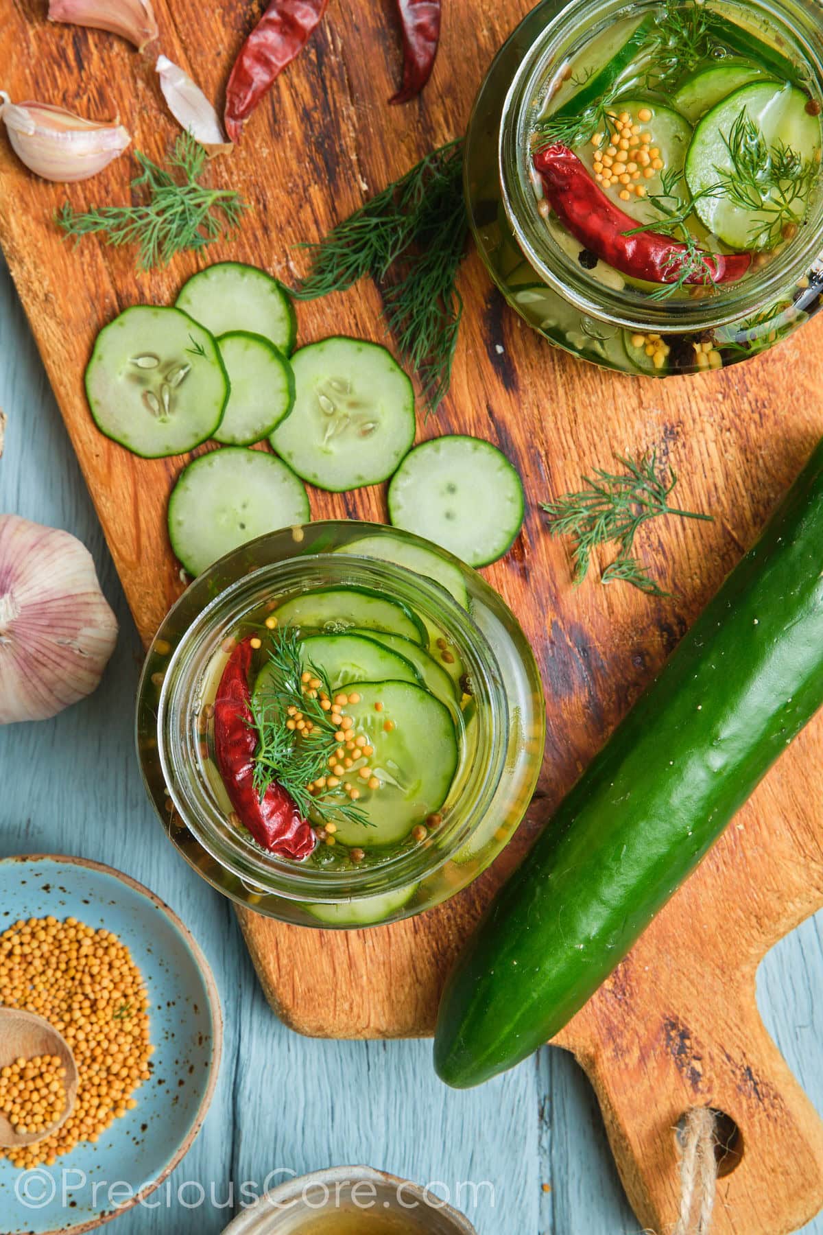 Two jars filled with pickled cucumbers.