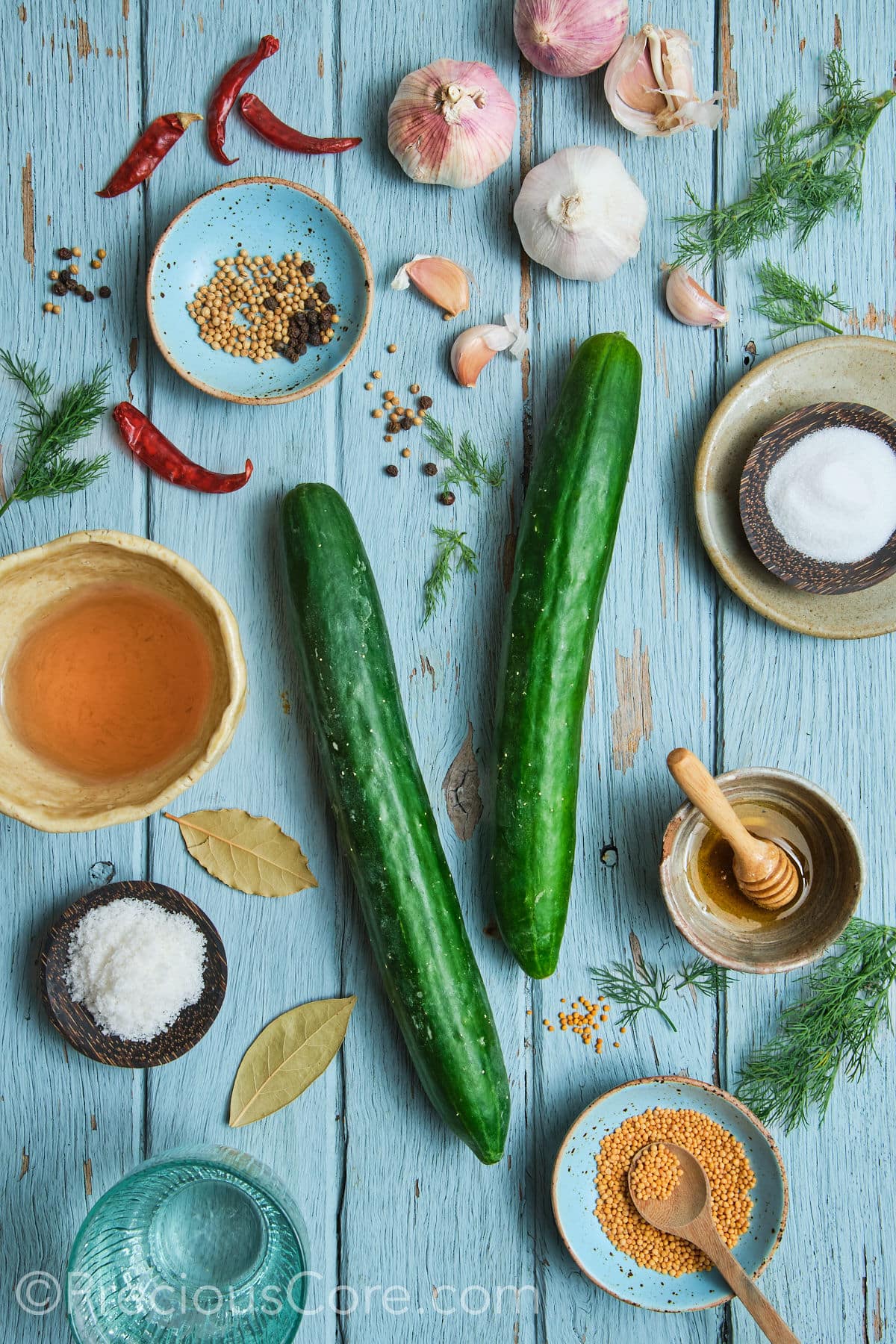 Quick pickled cucumbers ingredients on a blue board.