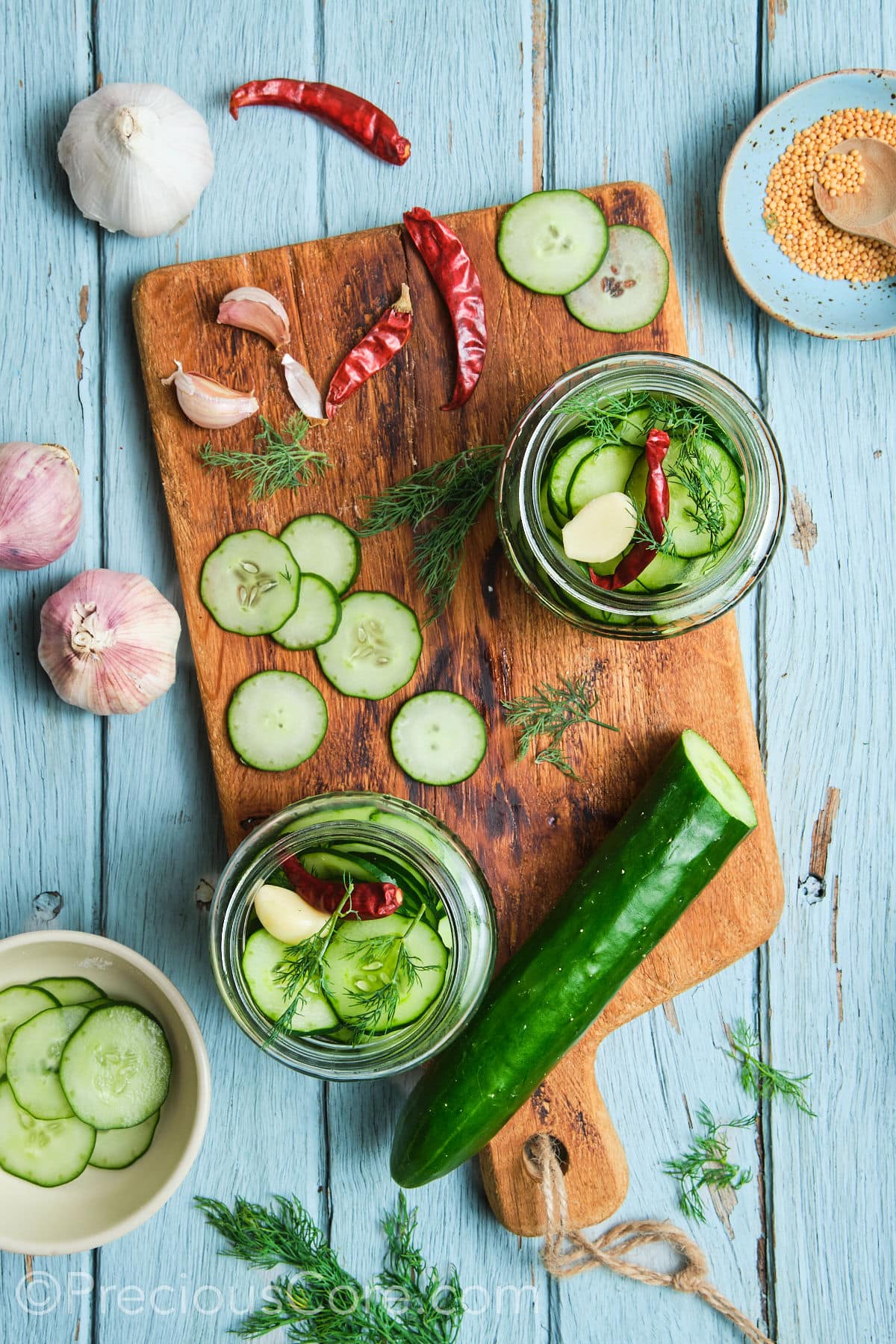 Sterilized jars with cucumber slices and other ingredients.