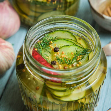 Square image of pickled cucumbers.