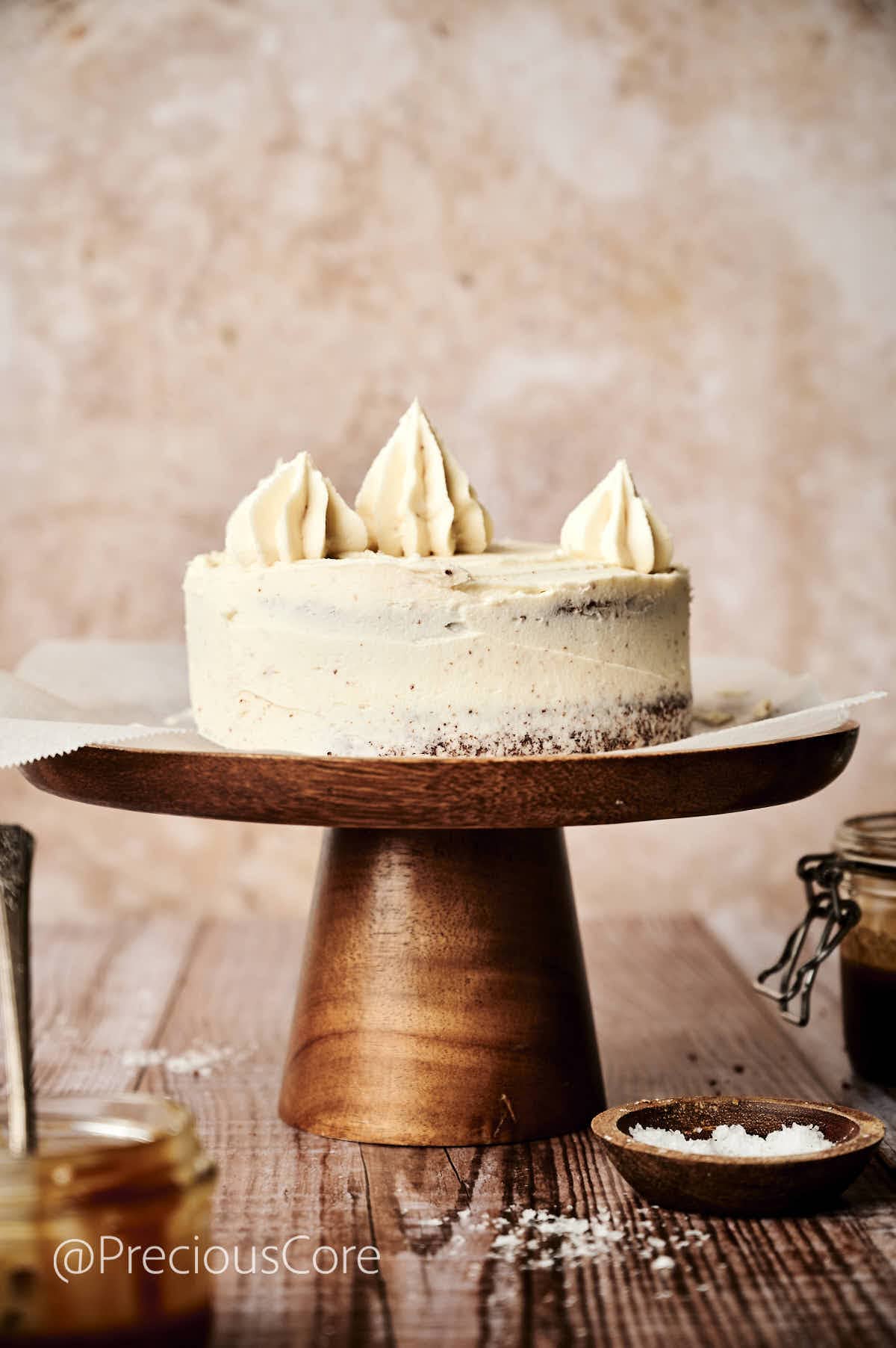 Salted caramel cake with more caramel frosting piped on top.