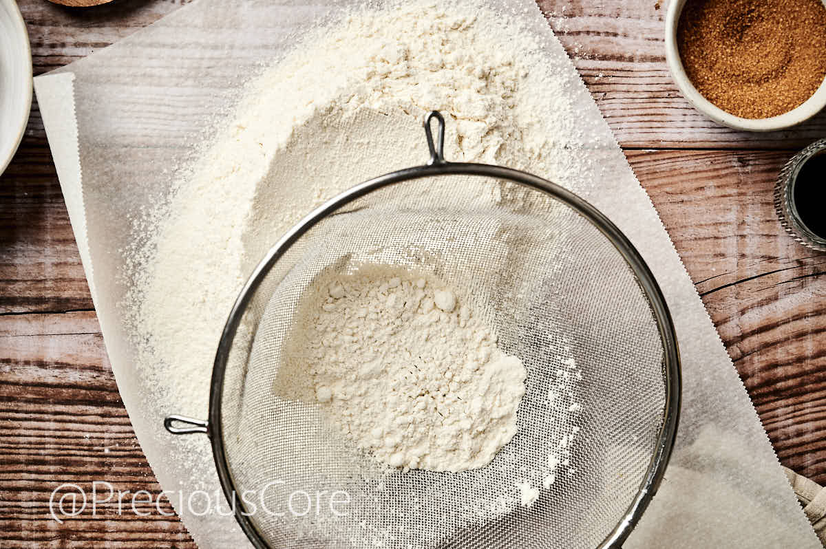 Sifting flour with a fine mesh sieve.