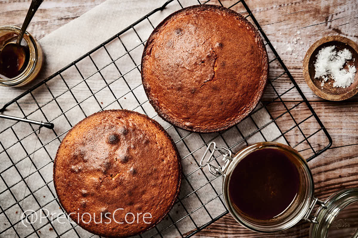 Two 8-inch cakes, cooling on a cooling rack.