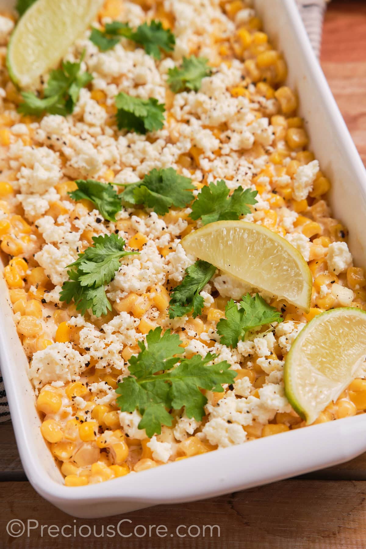 Close up of corn casserole topped with lime wedges.