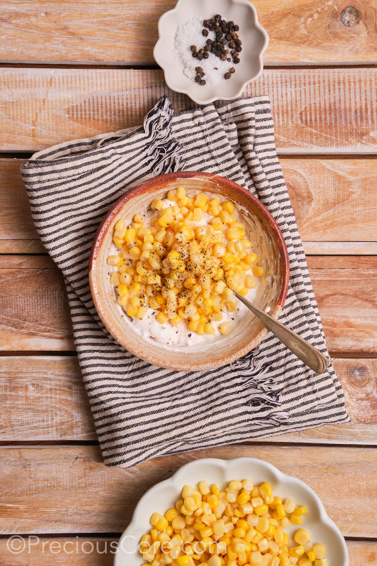 Mixing corn with a creamy sauce.