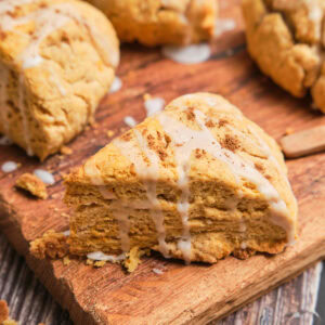 A triangle sweet potato scone with a white glaze on top.