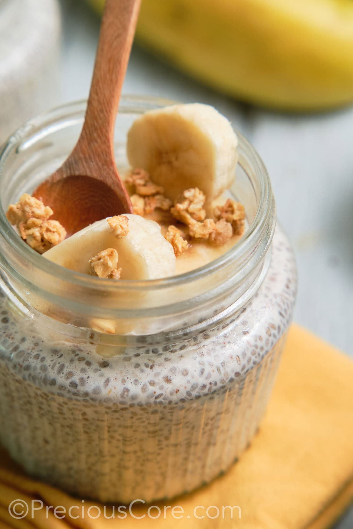 Spoon in a jar of banana chia pudding.