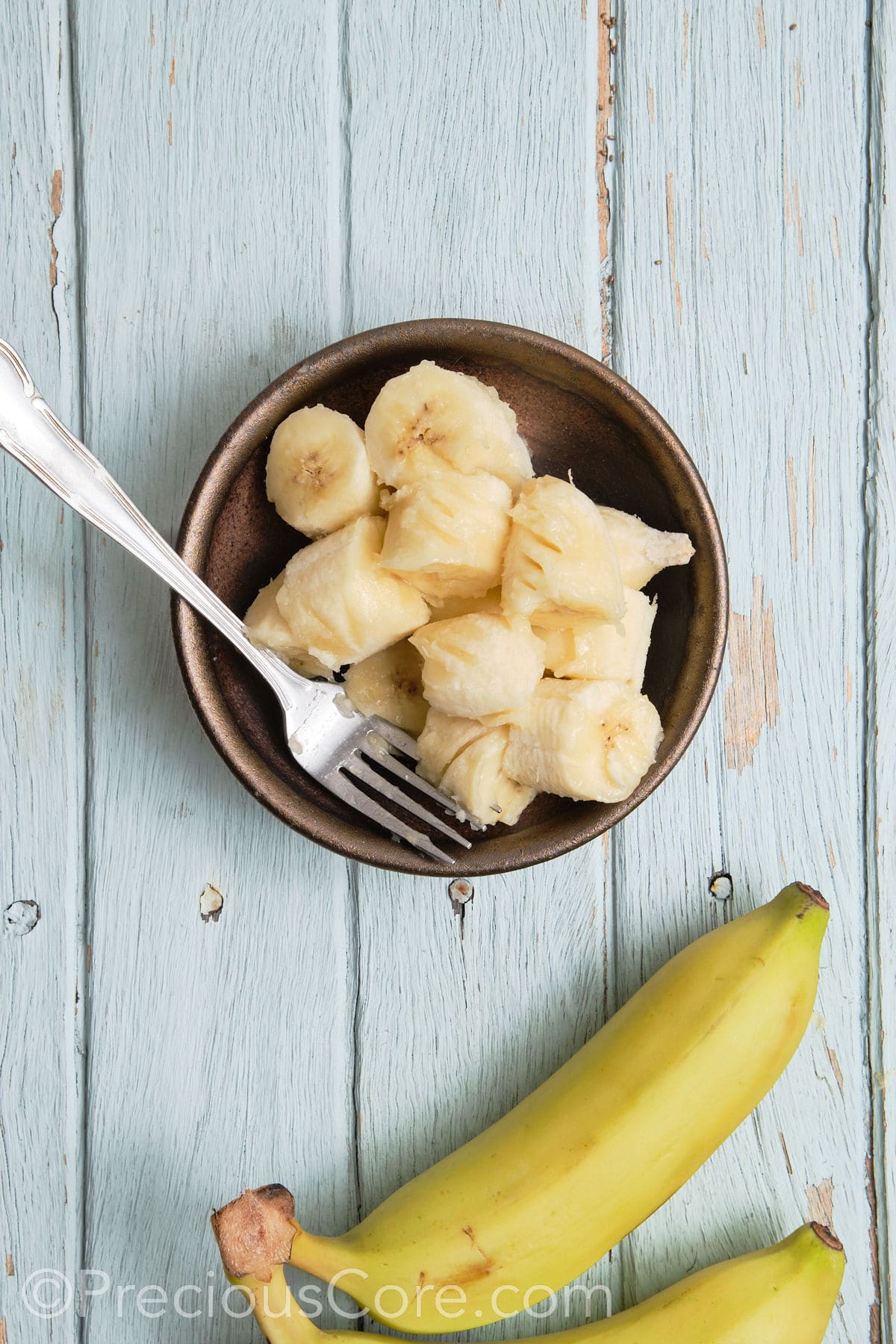 Mashing bananas in a bowl.