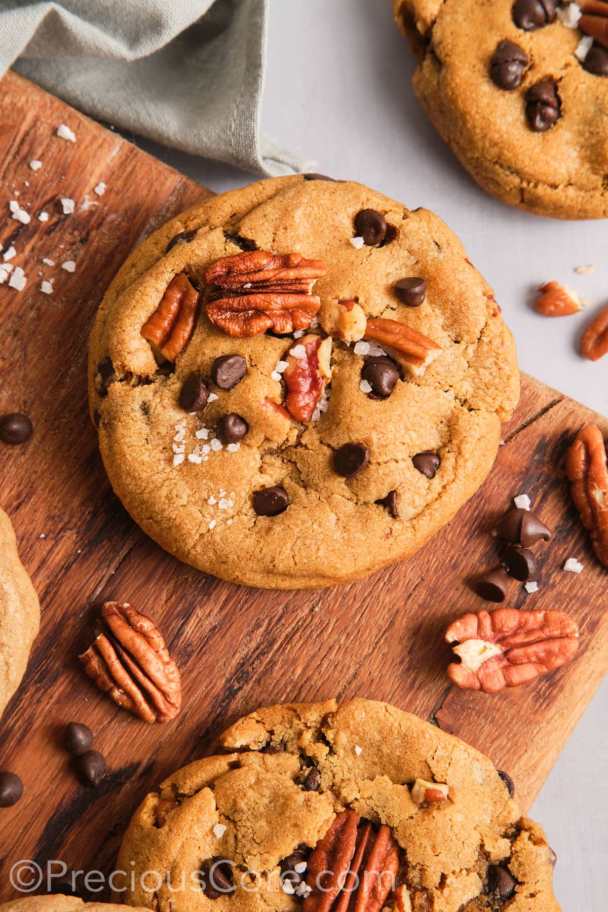 Crispy and chewy brown butter pecan cookies on a chopping board. 