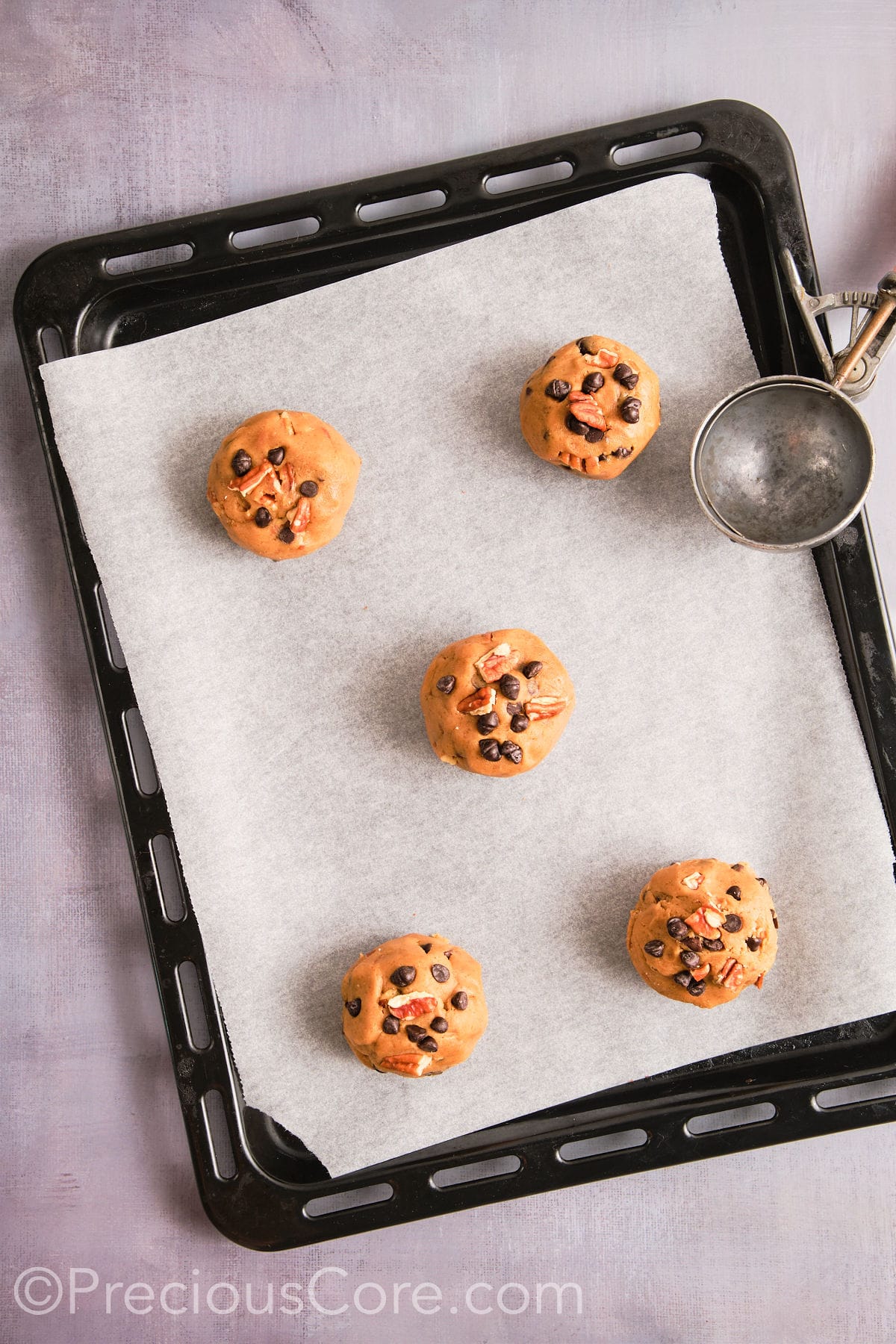 Cookie dough scooped onto a prepared baking sheet. 