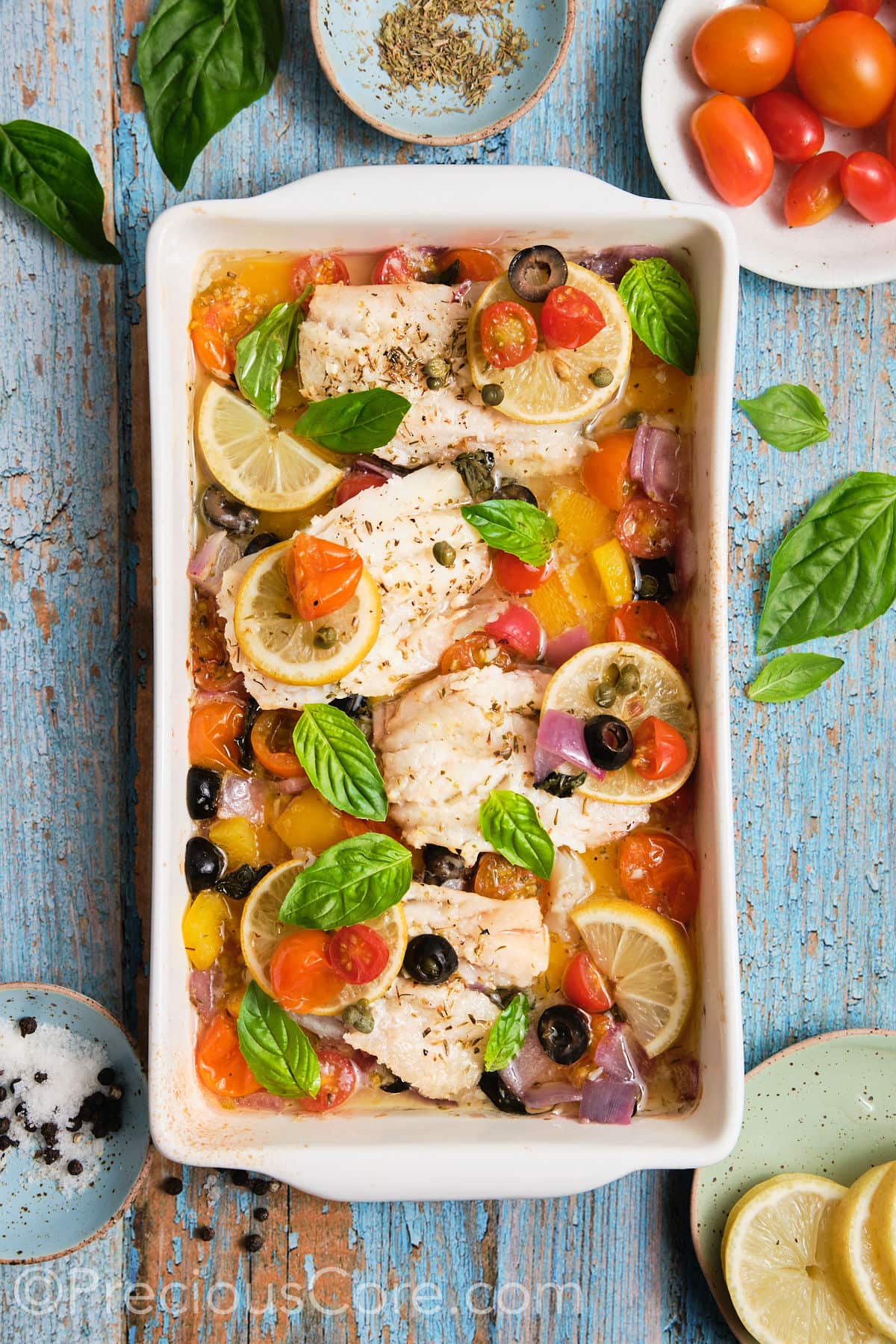 Mediterranean baked fish with veggies in a pan. 