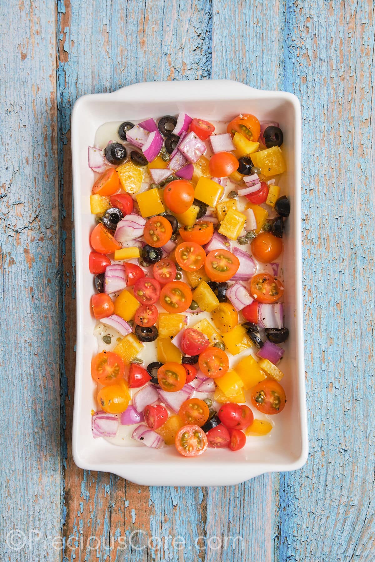 Chopped veggies arranged in a baking dish. 