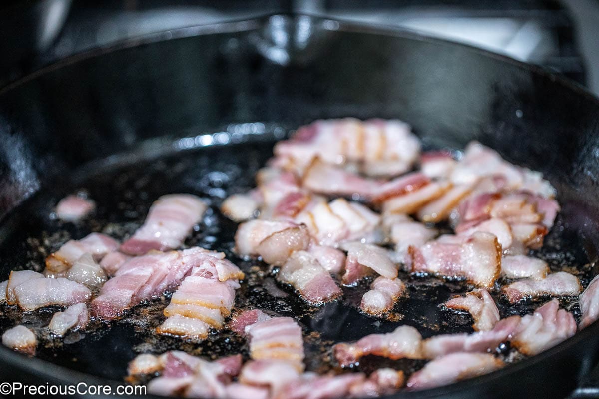 Bacon frying in a skillet.