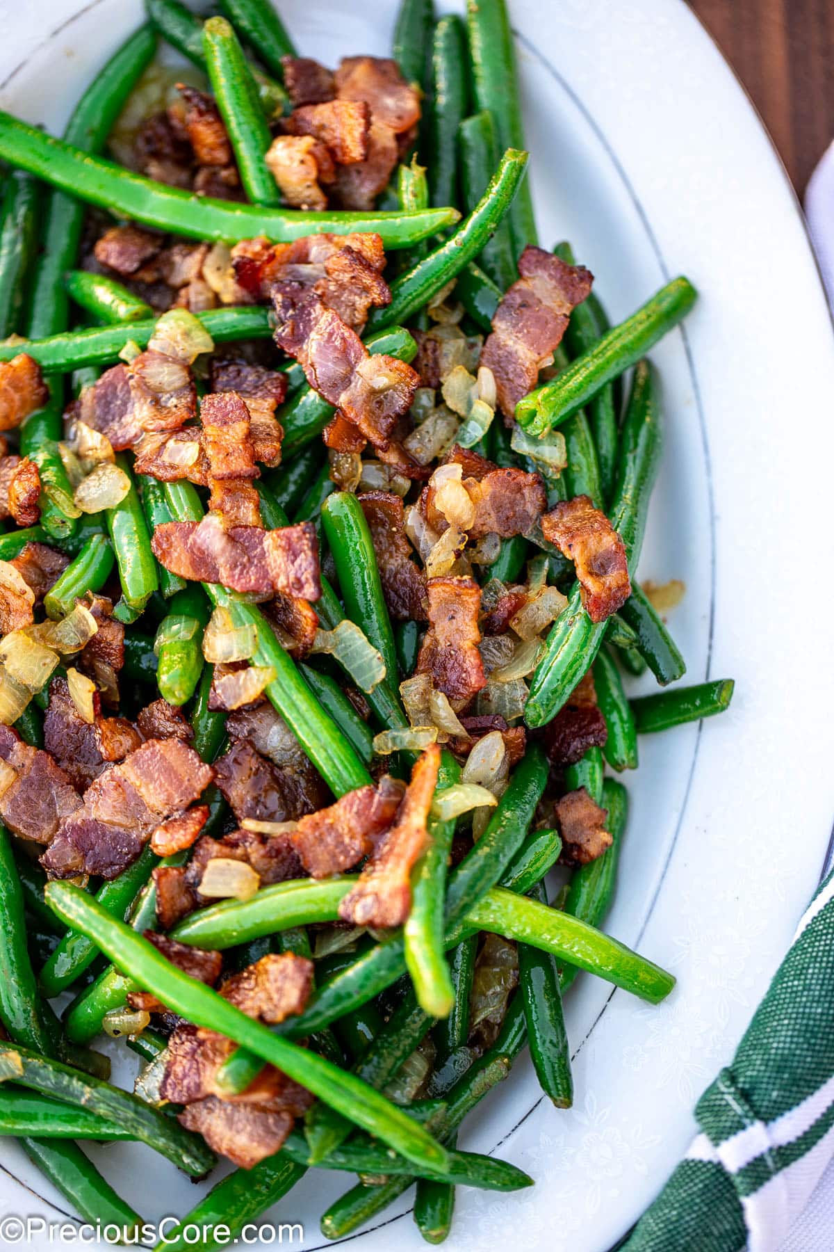 Bright colored green beans and bacon on tray.